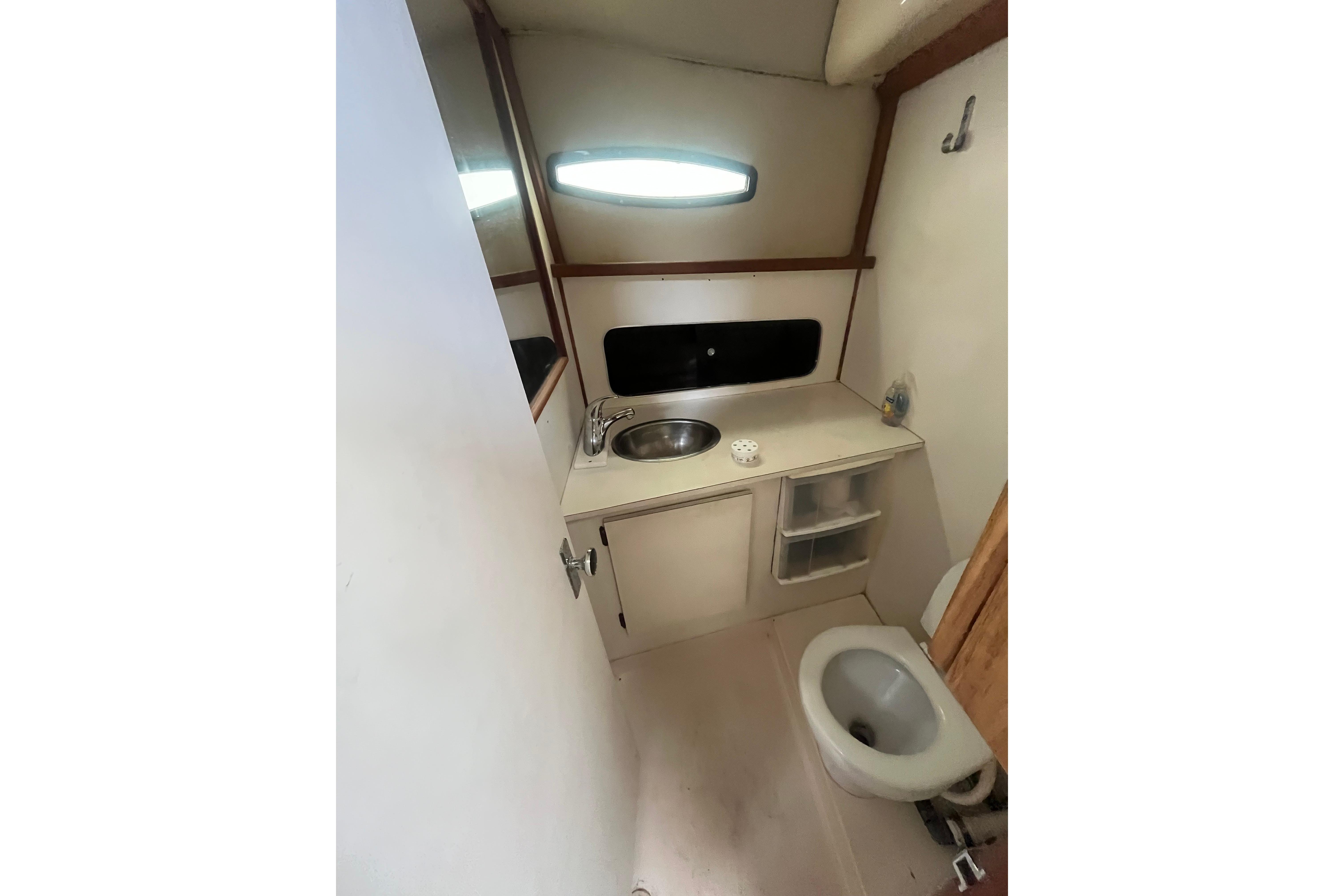 Compact bathroom in 1989 Blackfin 31 Combi boat with sink and toilet.