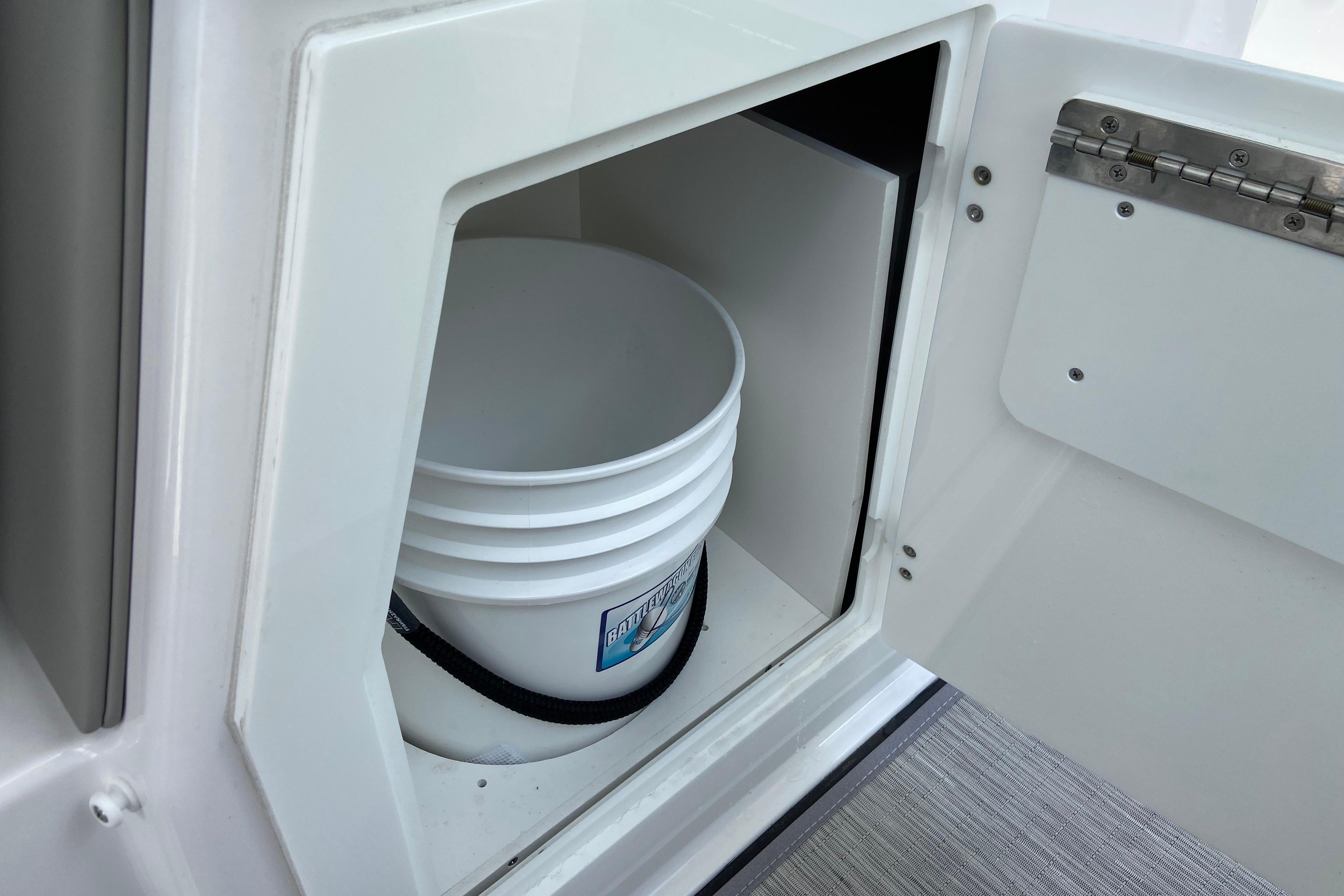 Storage compartment with bucket on 2026 Monterey Elite 30 OB boat.