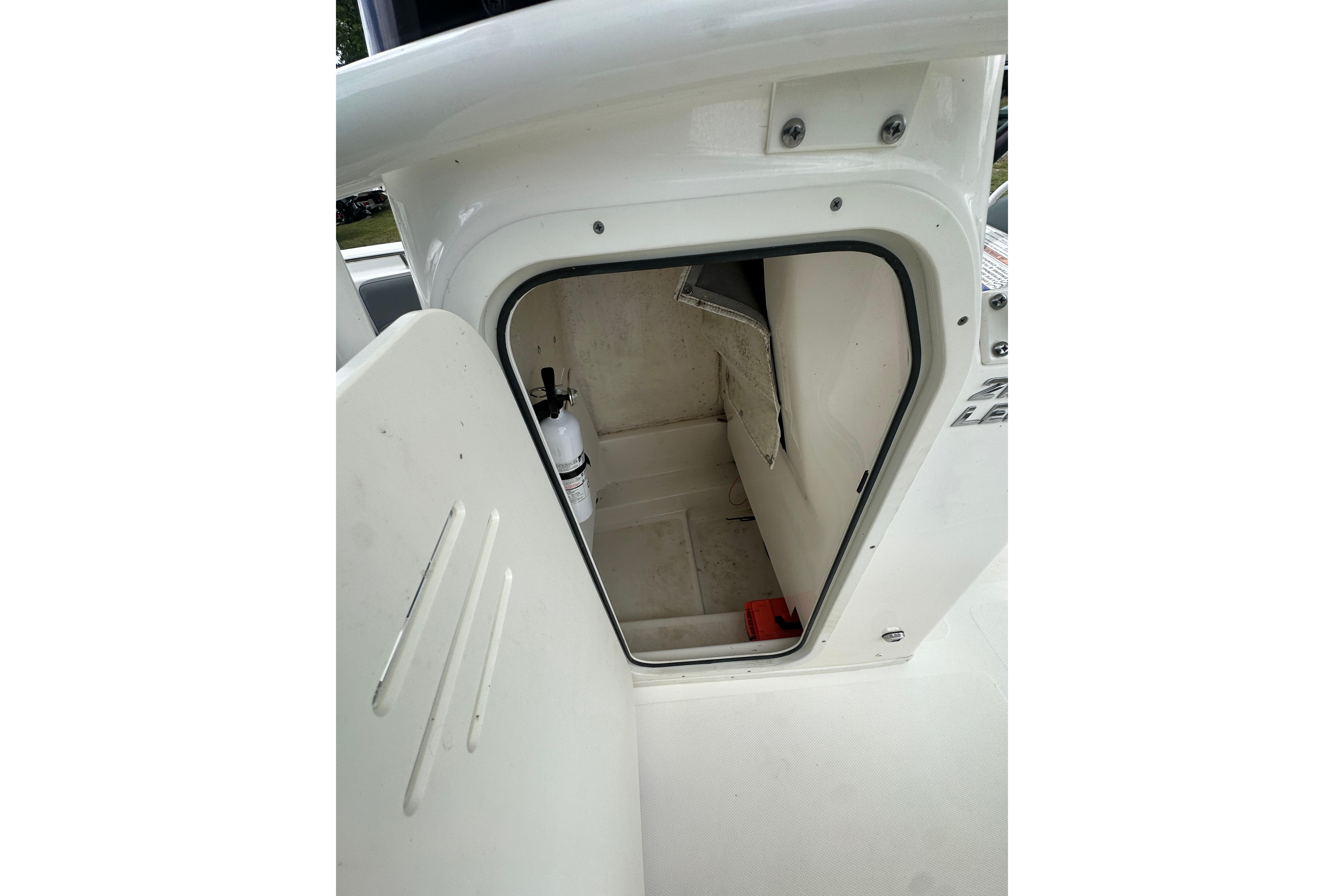 2023 NauticStar 2102 Legacy boat storage compartment with fire extinguisher.