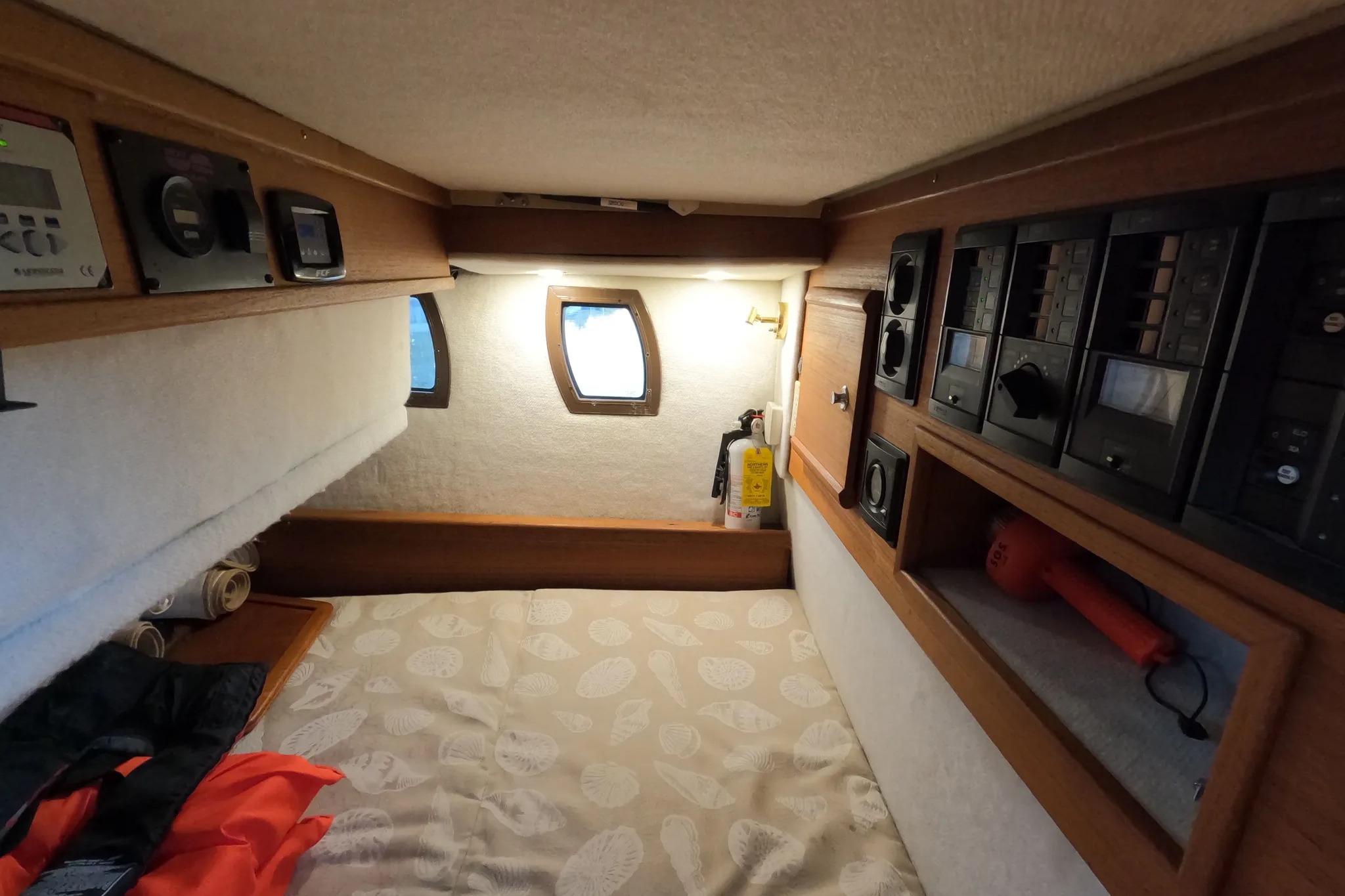 Interior cabin of 2015 Ranger Tugs R-29 S with control panels and cozy bedding.