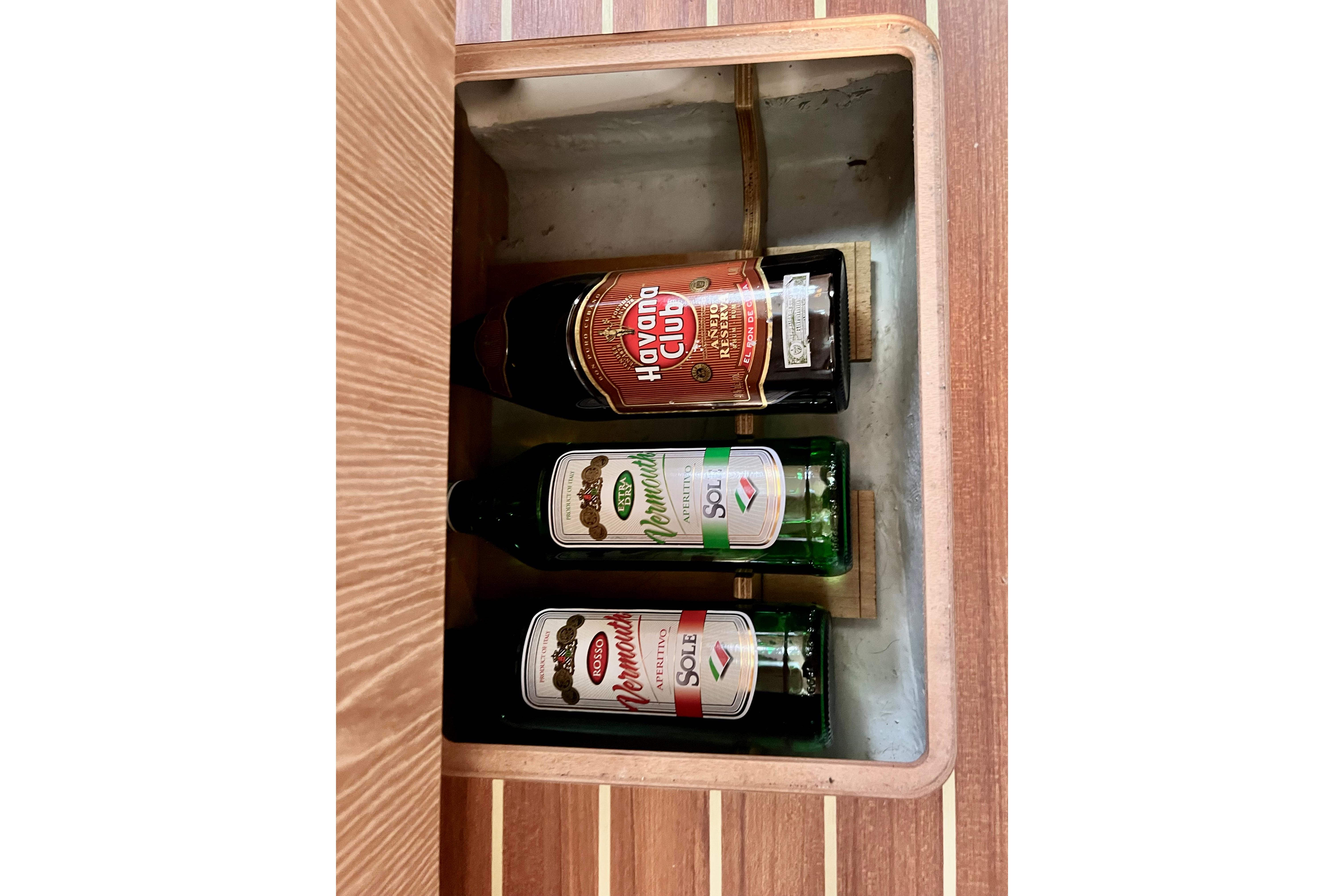 Bottles stored in a wooden compartment on a 2016 Hanse 455 yacht.