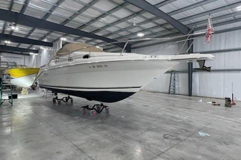 1998 Sea Ray 270 Sundancer boat in a spacious indoor storage facility.