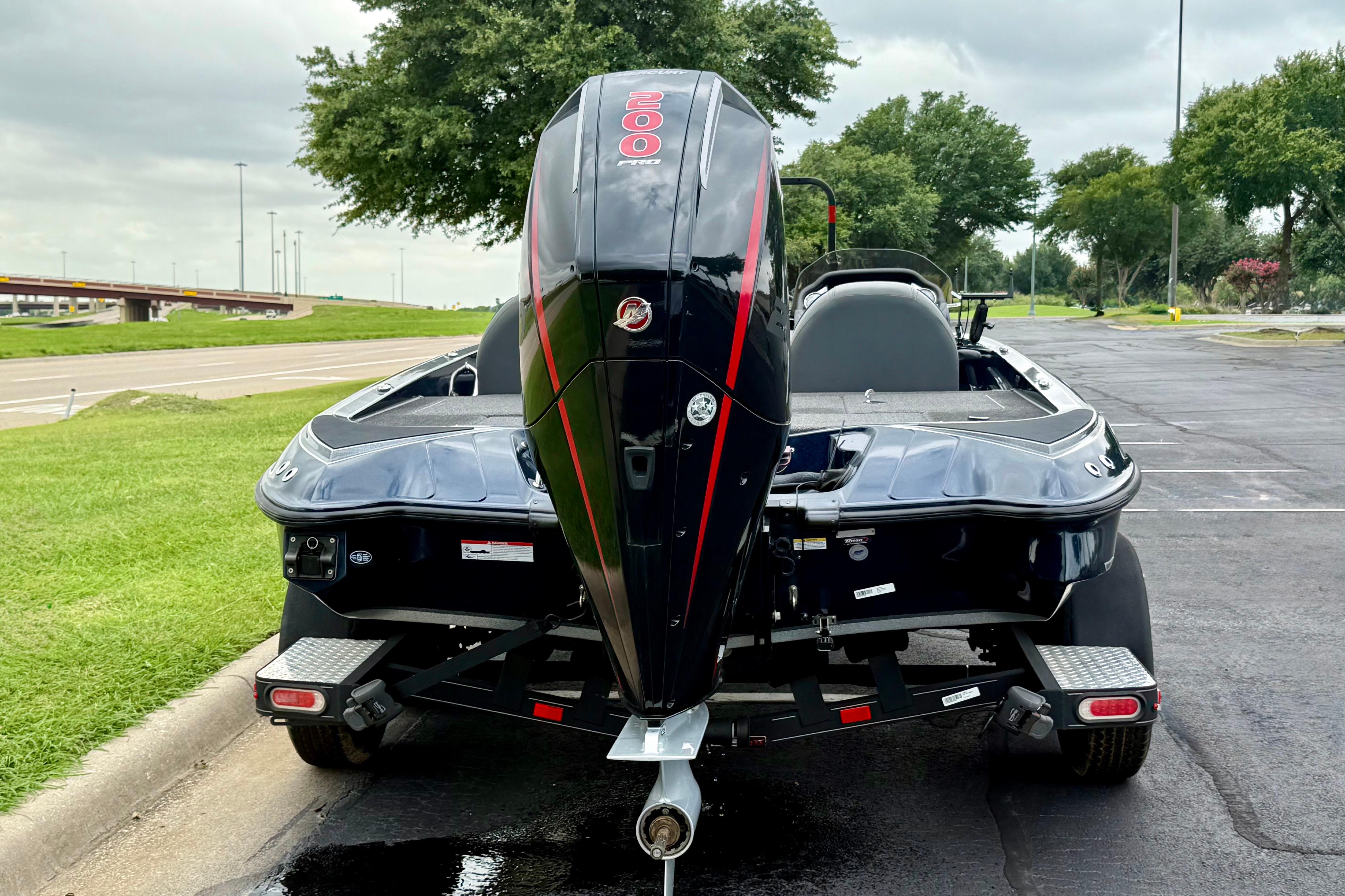 2023 Triton 18 TrX boat with powerful outboard motor, parked on a paved road.