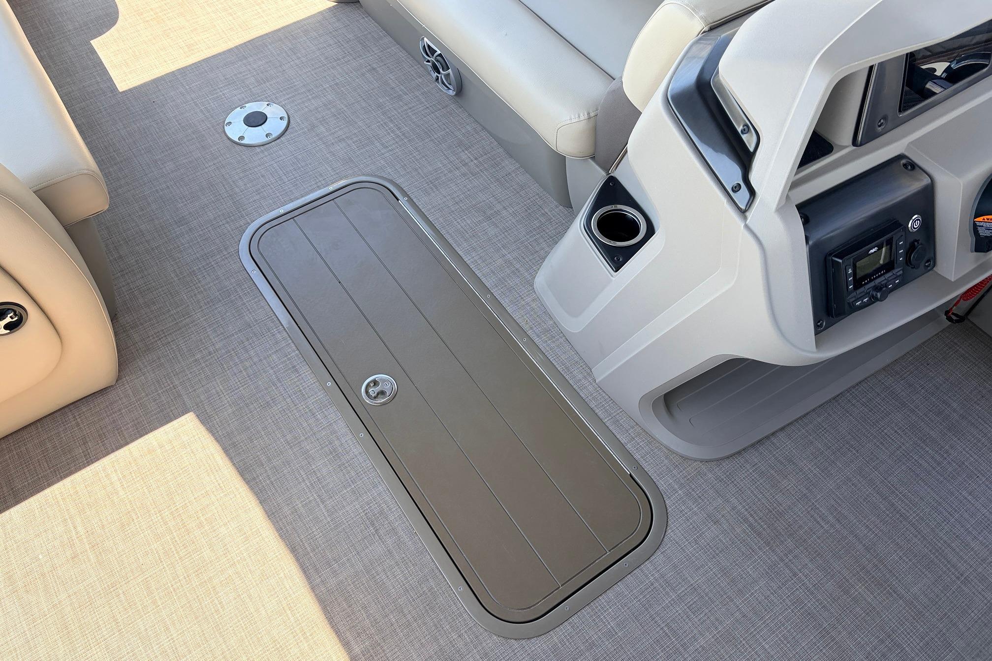 2024 Sun Tracker SportFish 22 XP3 boat interior with storage hatch and control panel.
