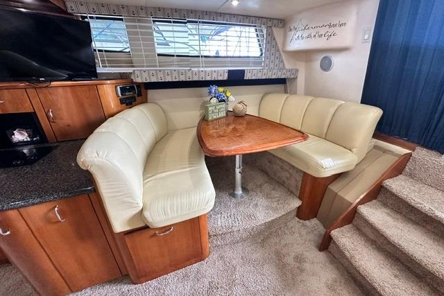 Interior of 2004 Carver 360 Mariner yacht with cozy dining area and plush seating.