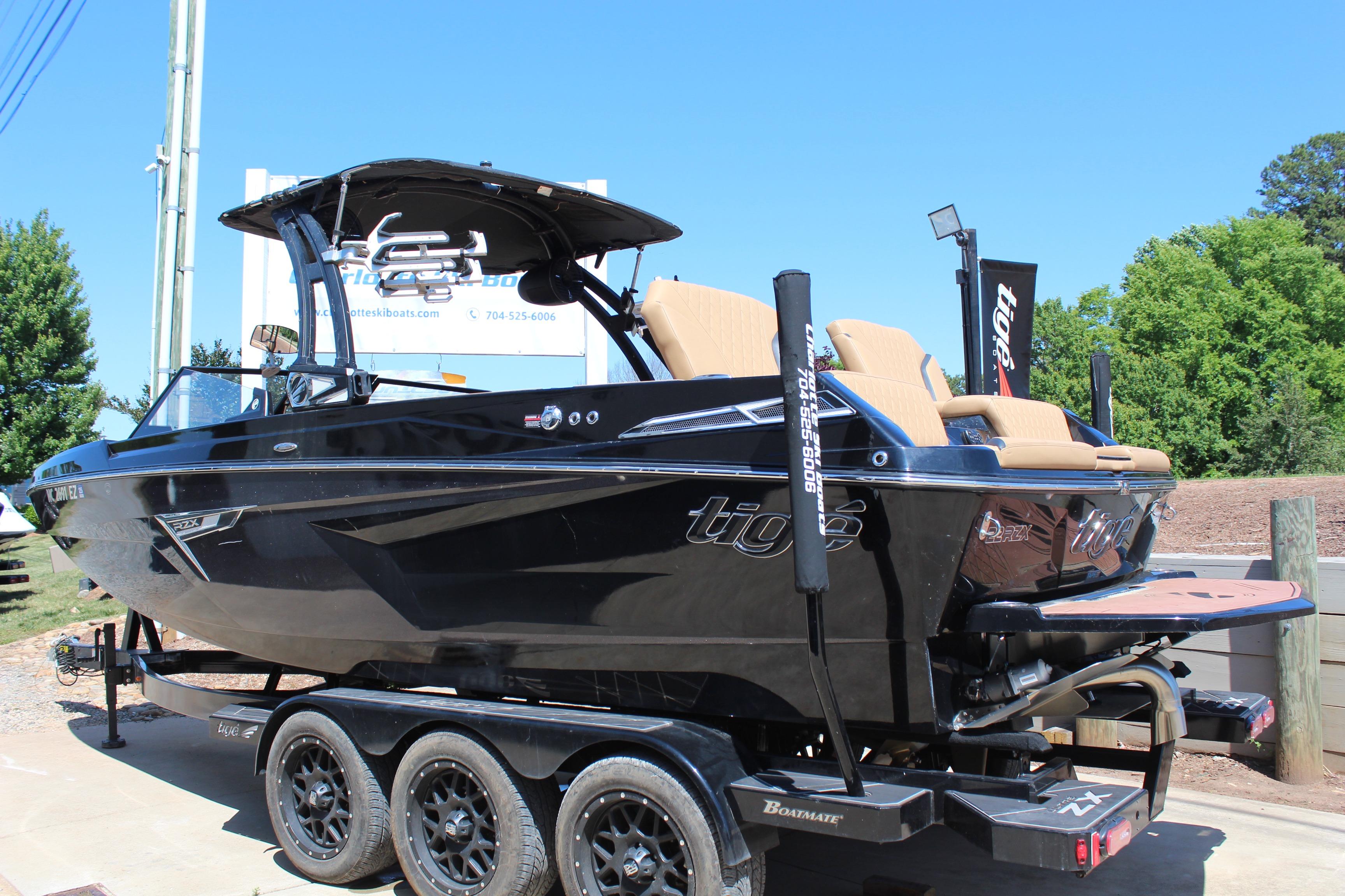 2022 Tigé 22RZX boat on trailer, sleek black design, outdoor display.
