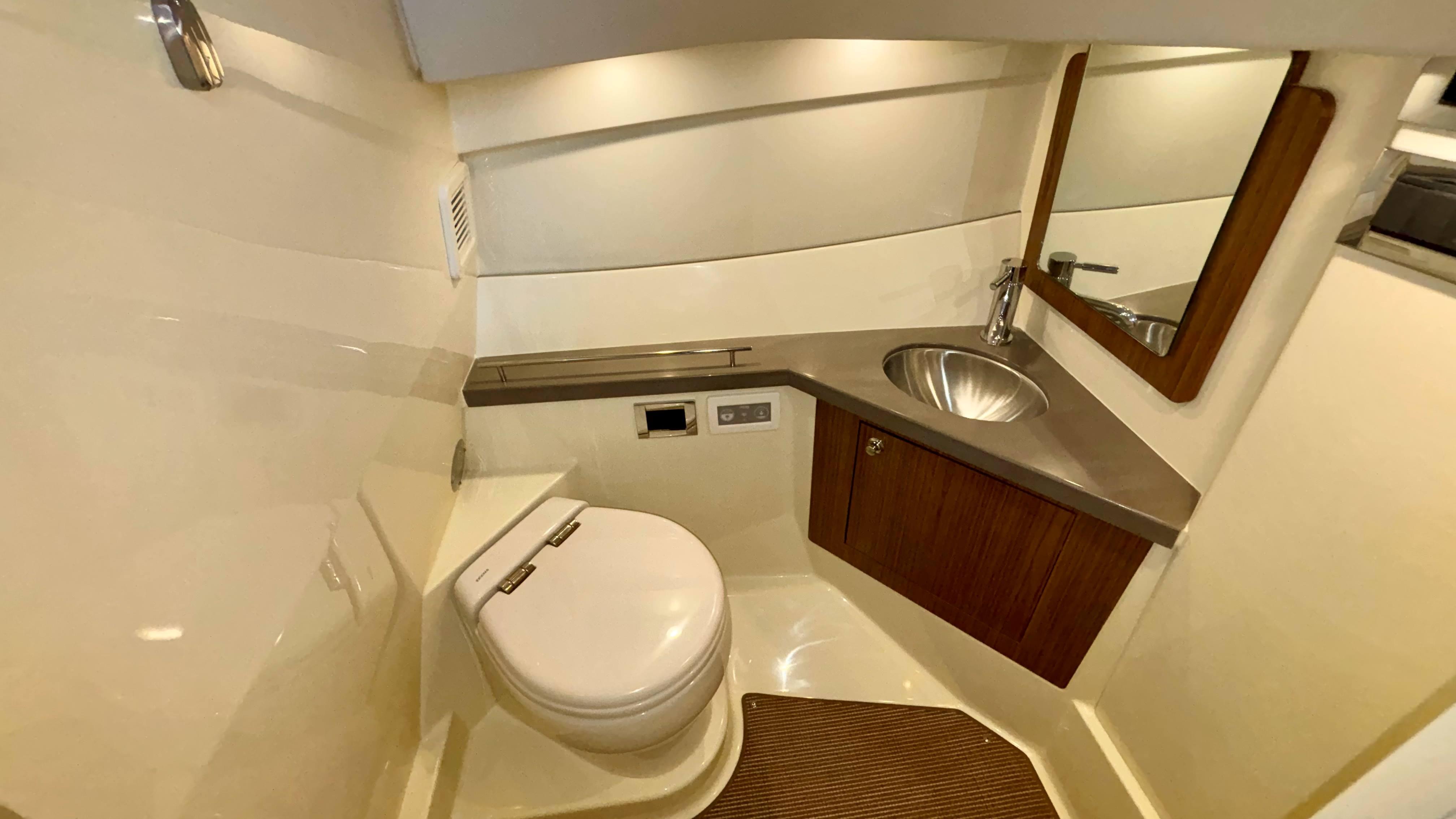 2024 Chris-Craft Calypso 32 CT boat bathroom with modern fixtures and wooden accents.