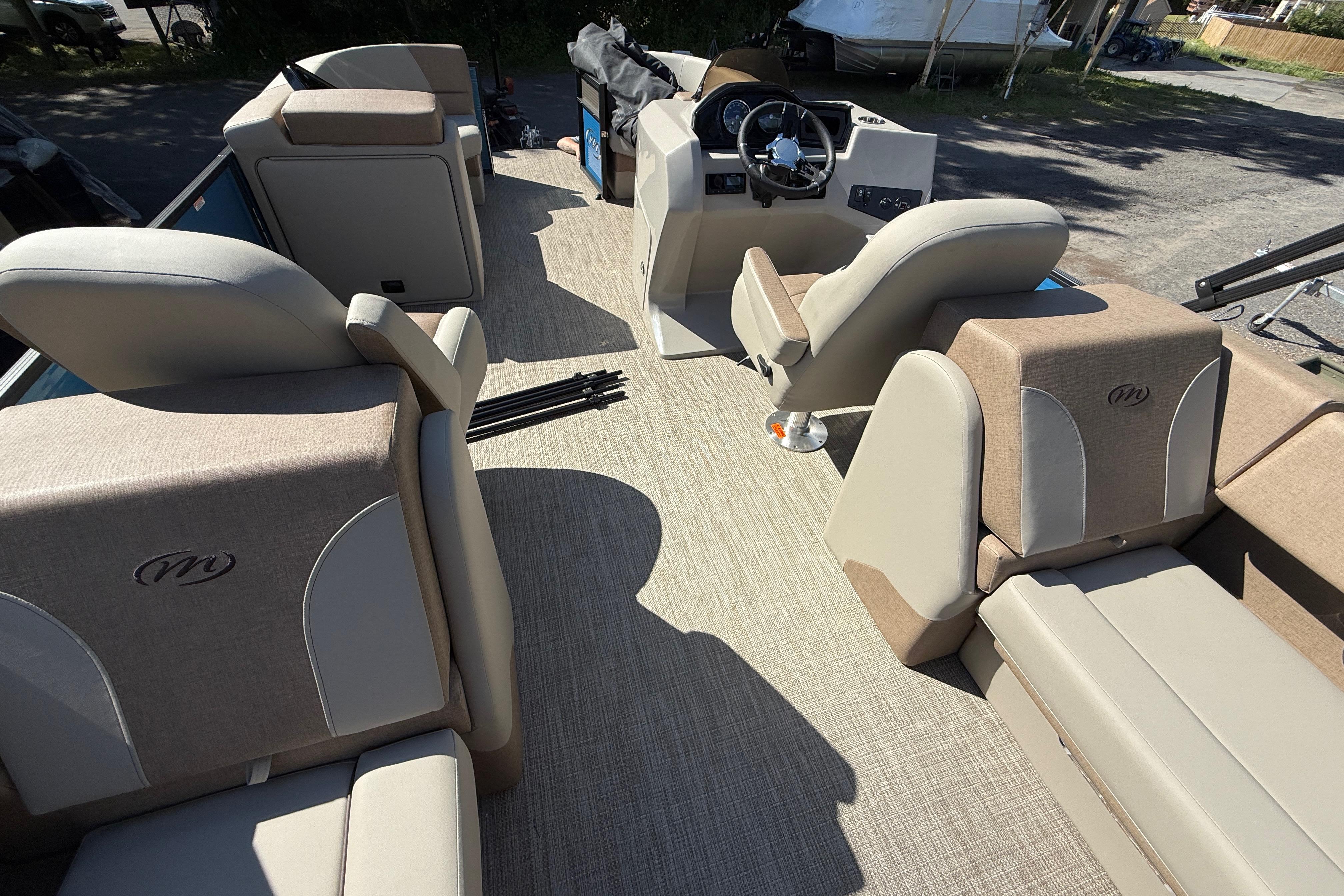 Interior of 2027 Manitou Aurora RF 23 pontoon boat with beige seating and steering console.