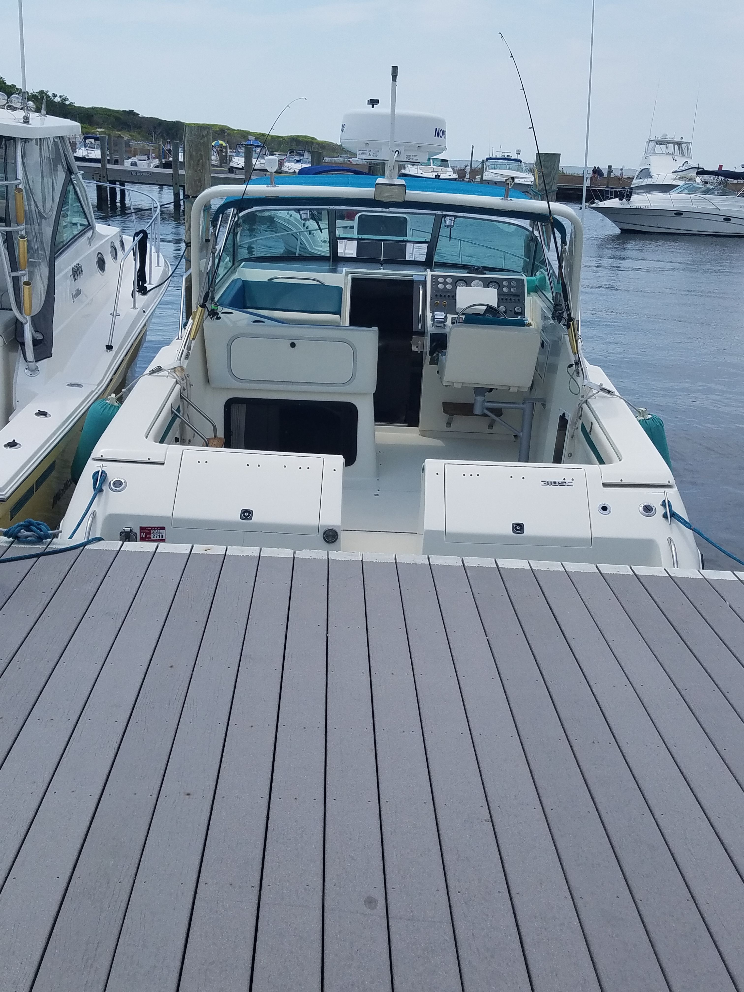 A 1989 Tiara Yachts Slickcraft docked. It features an open cockpit and is equipped with electronics.