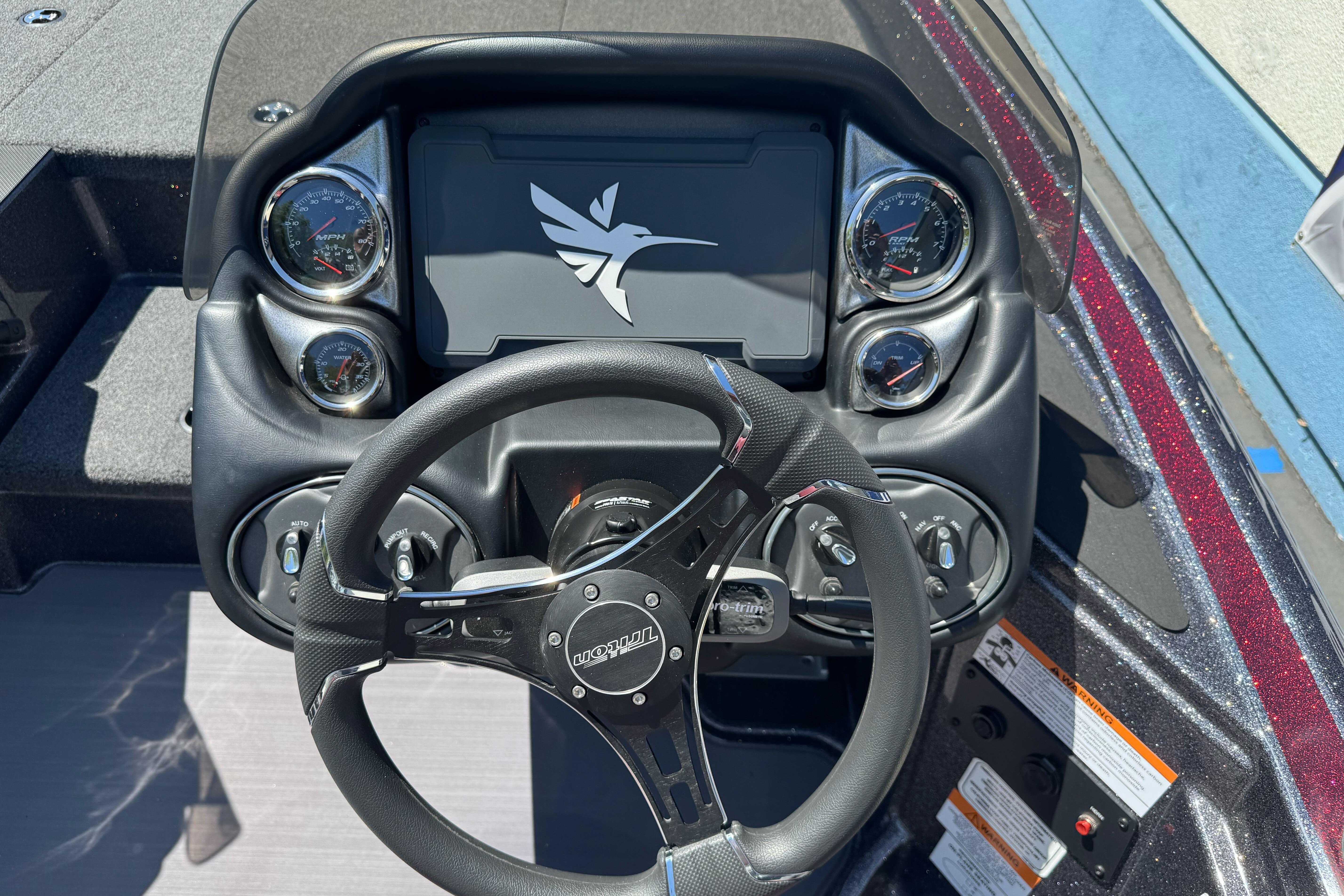 Dashboard of a 2026 Triton 18 TrX boat with steering wheel and gauges.