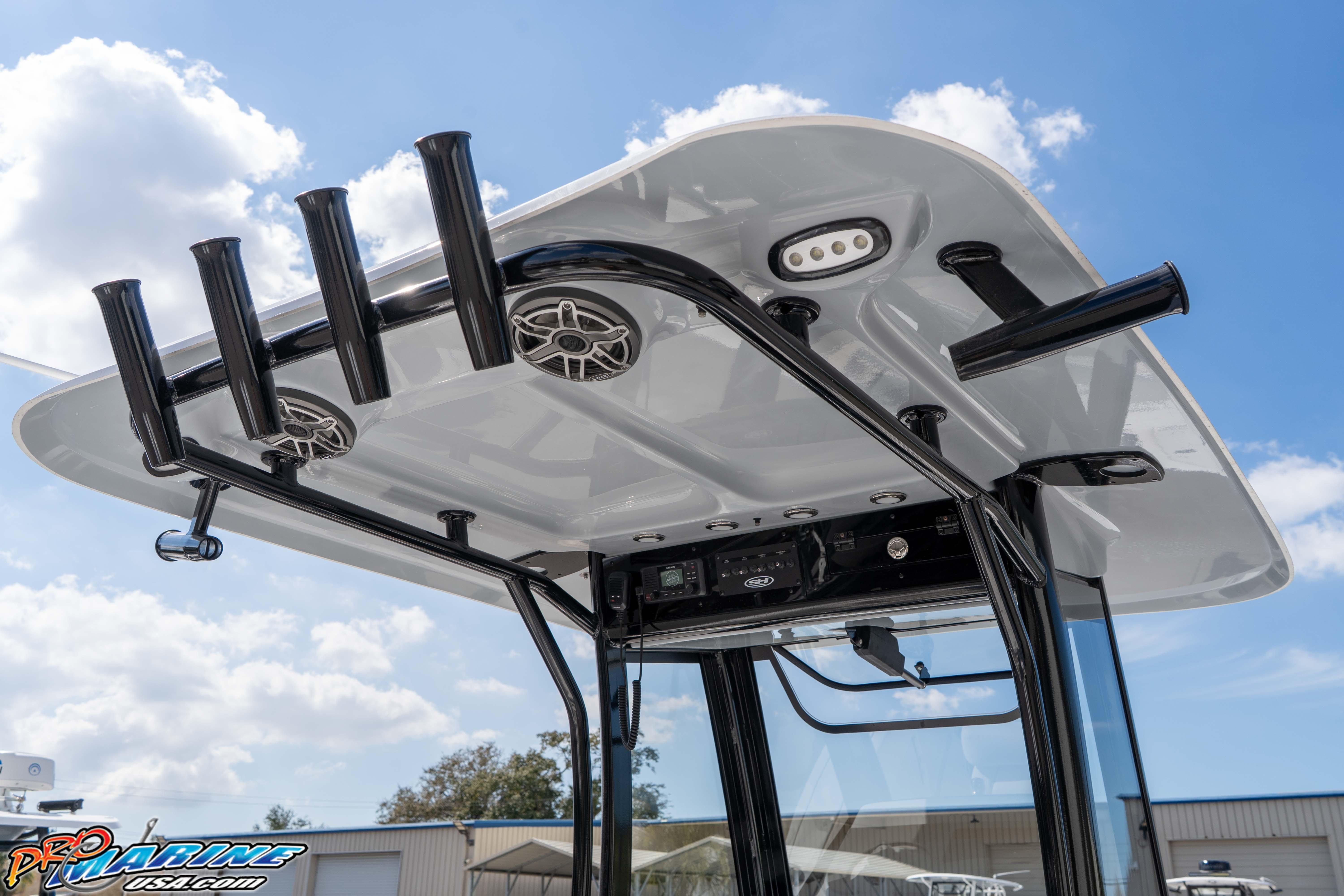 2026 Sea Hunt Gamefish 25 T-top with rod holders and speakers under a blue sky.