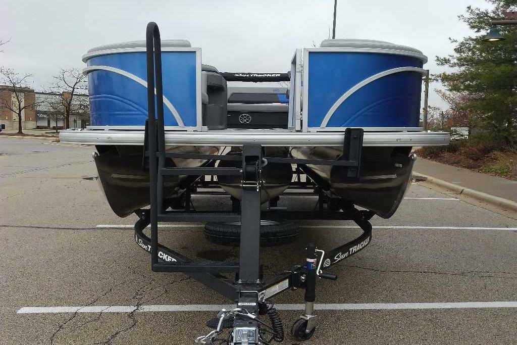 2026 Sun Tracker Party Barge 22 RF XP3 pontoon boat on trailer in parking lot.