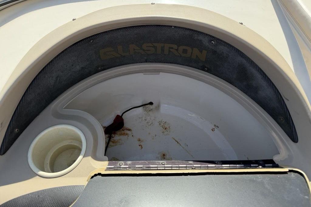 1999 Glastron GT 225 boat interior with cup holder and storage compartment.