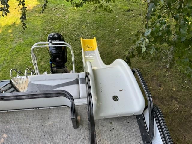 Pontoon boat with slide, Crest Caribbean 250 L, 2017 model, parked on grass.