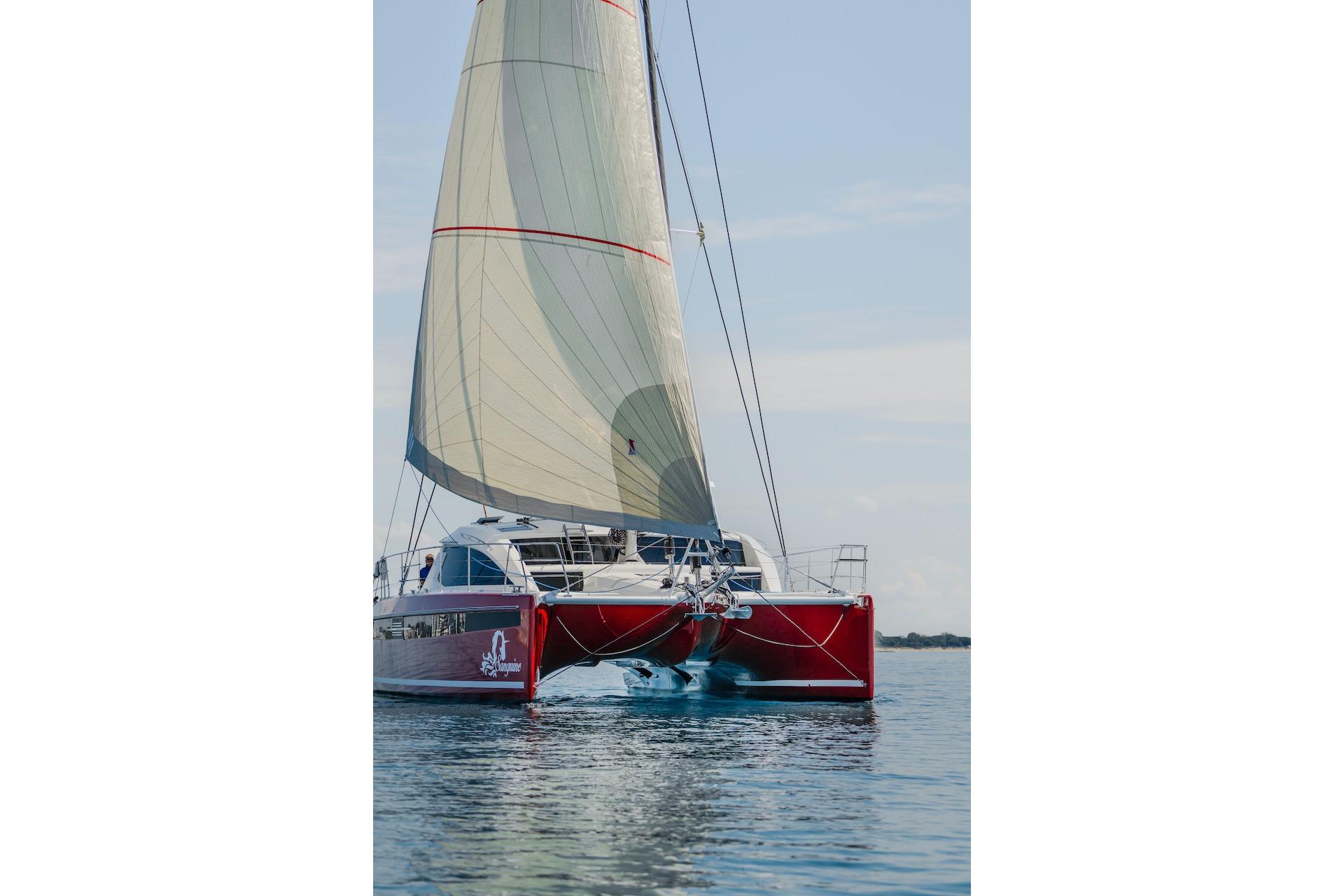 Red Privilege Signature 510 catamaran sailing on calm waters, 2025 model.