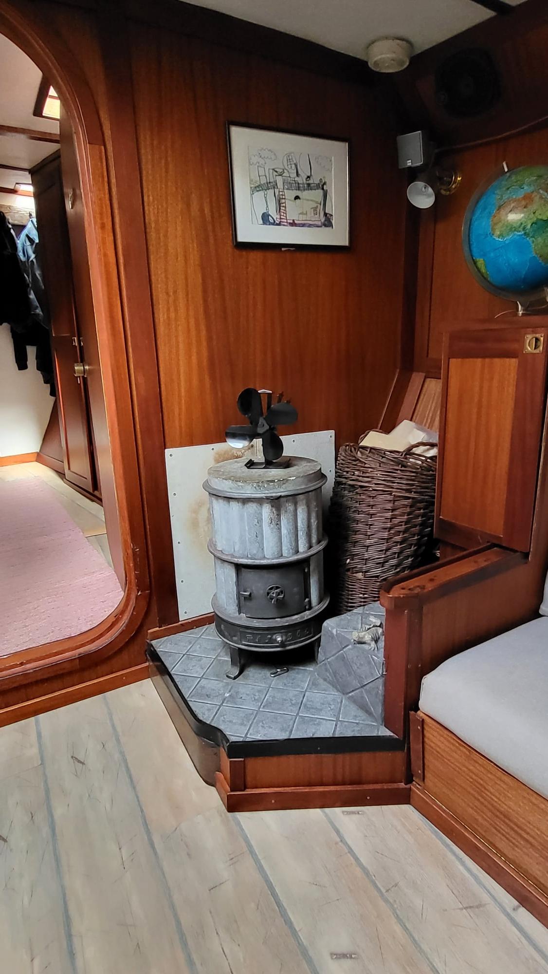 Interior of 1986 Schooner Jackie with wood paneling and vintage stove.