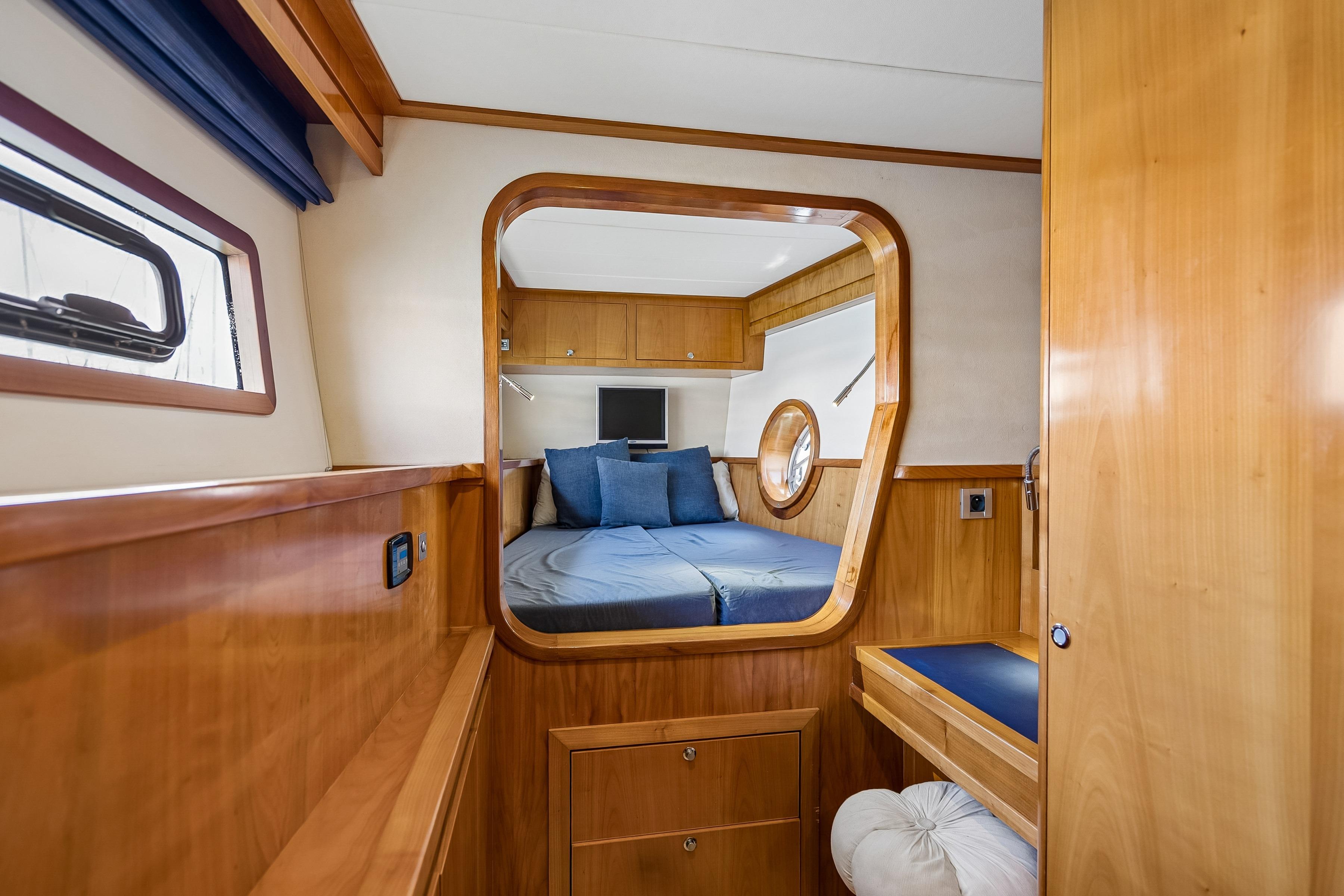 Luxurious interior of 2009 Catana 65 yacht with wooden finish and cozy bedroom.