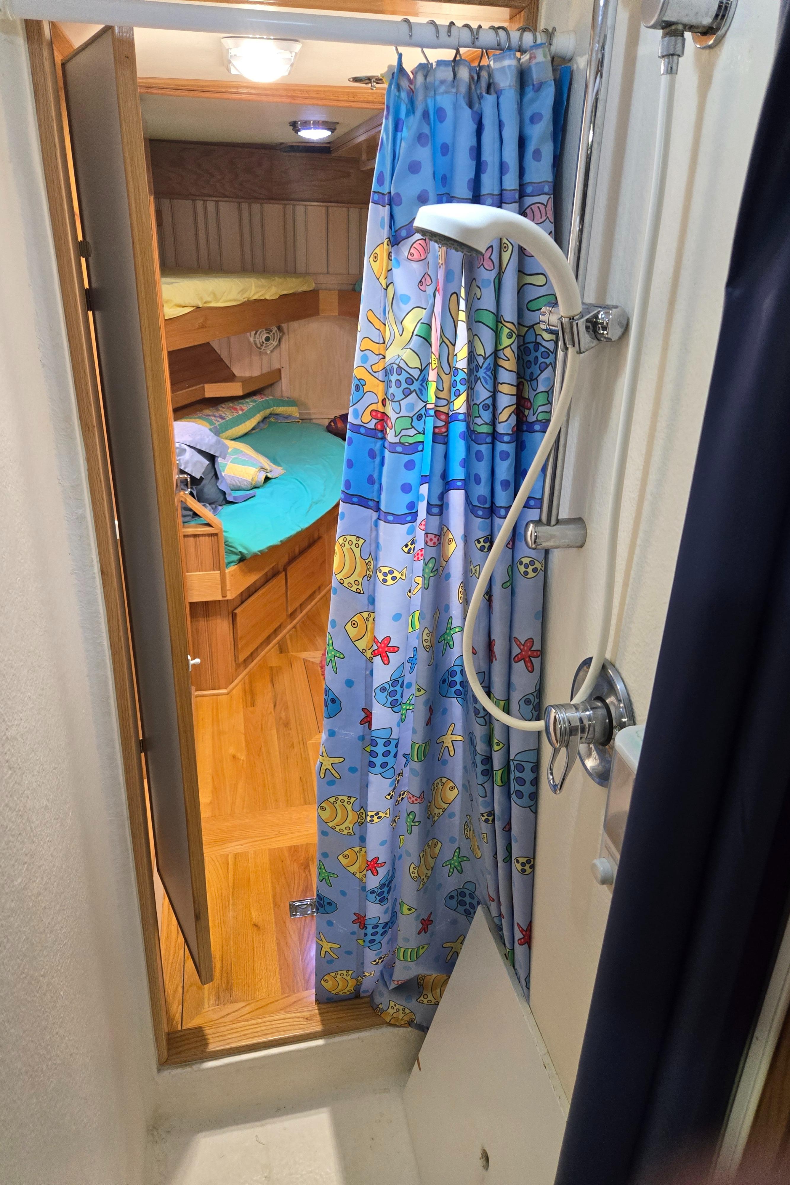 Compact shower area in 2000 Expedition custom vehicle with colorful curtain and cozy interior.
