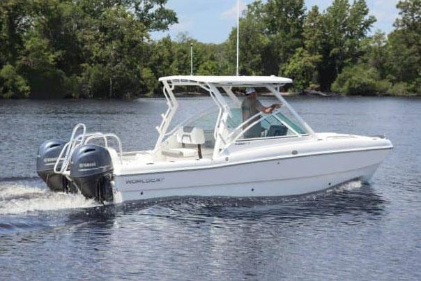 Manufacturer Provided Image: 2026 World Cat 230 DC boat cruising on a calm lake with lush green trees.