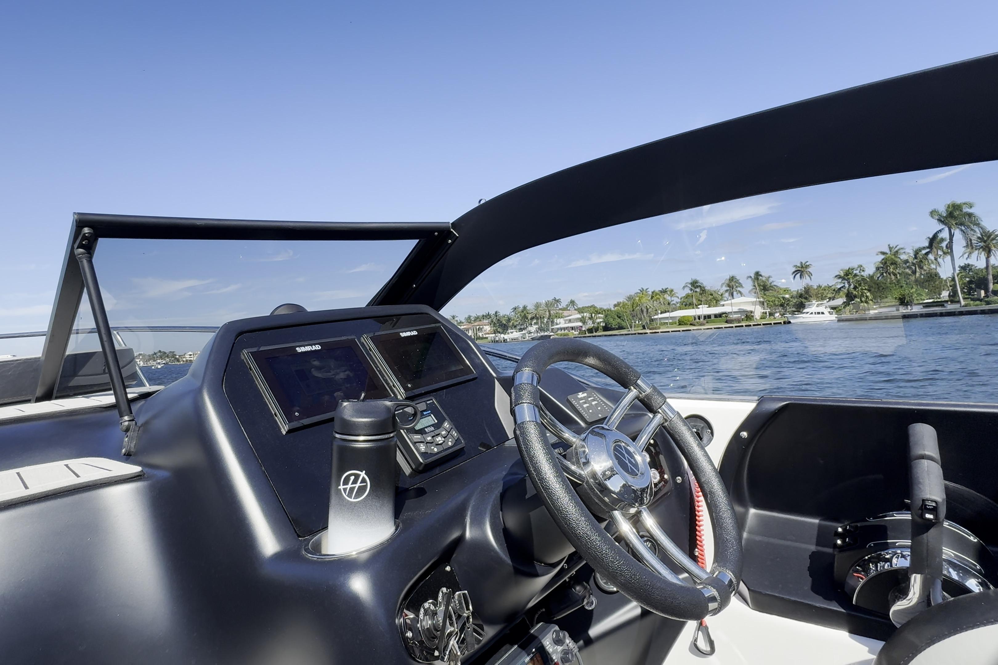 Helm of Hanover 305 boat, 2027 model, with steering wheel and navigation screens on a sunny day.