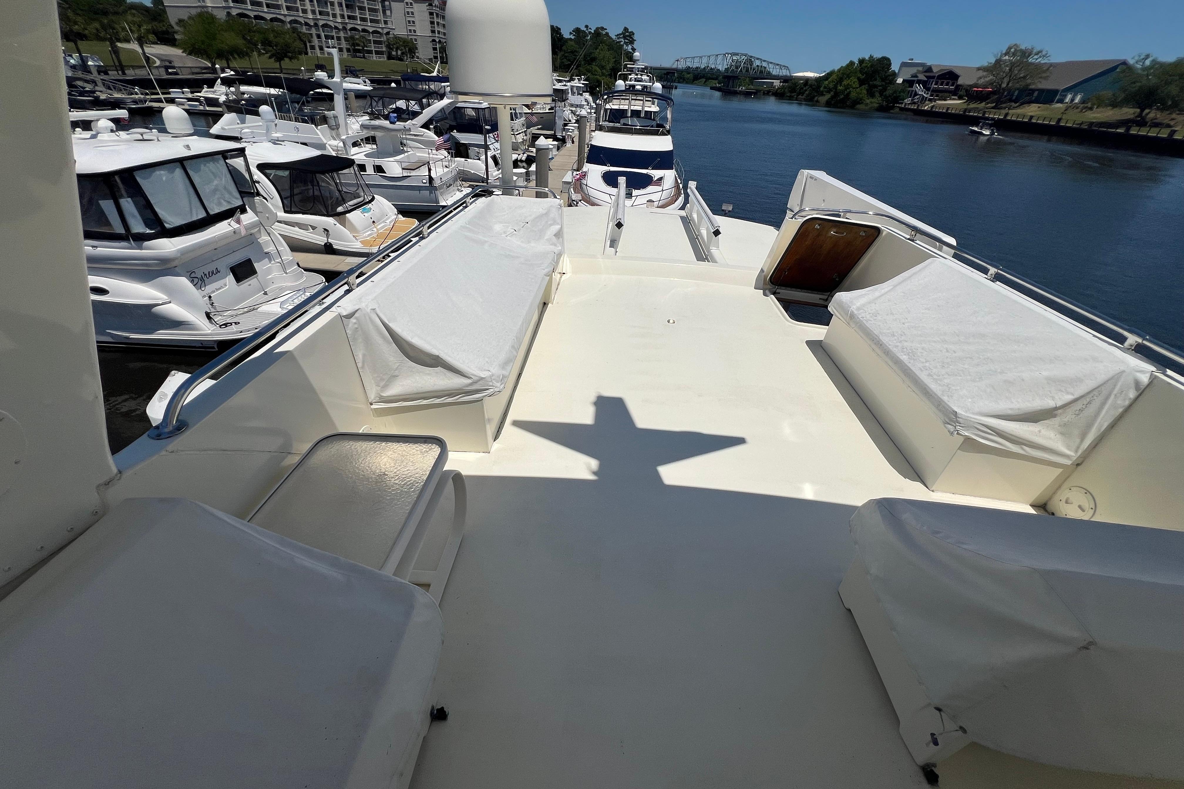 1987 Hatteras 70 Cockpit Motor Yacht docked, featuring spacious deck and marina view.