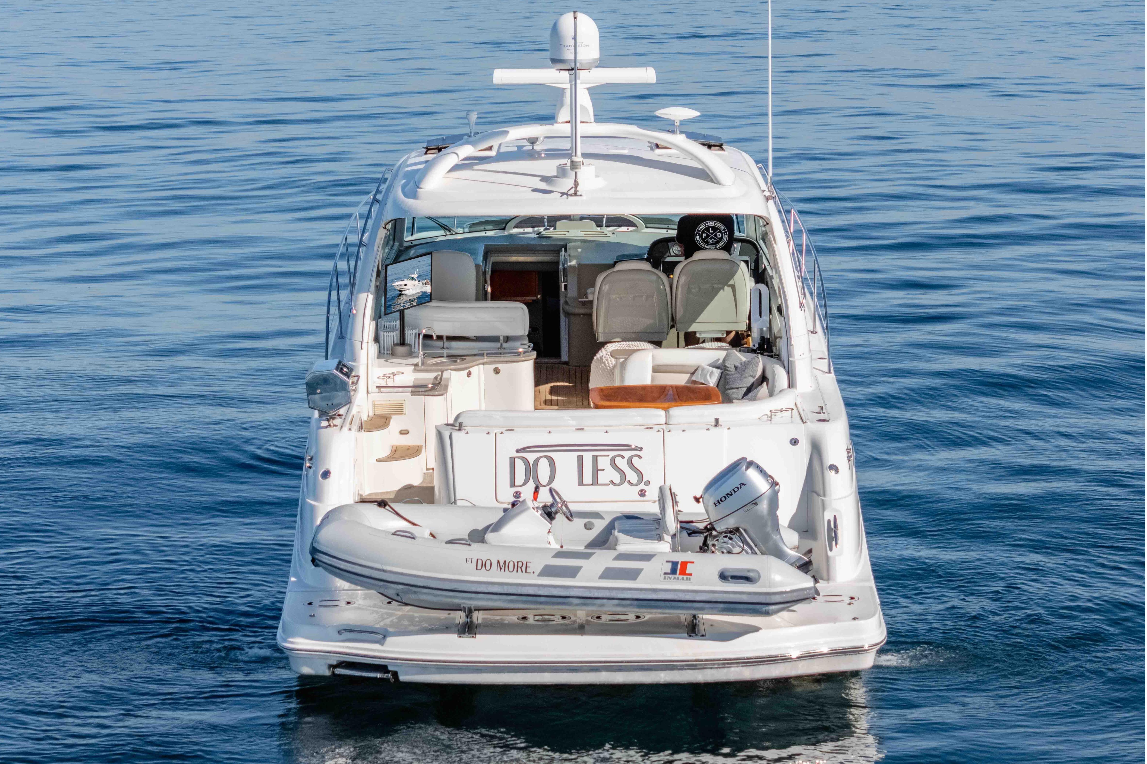 2007 Sea Ray 48 Sundancer yacht on calm water, rear view with dinghy attached.