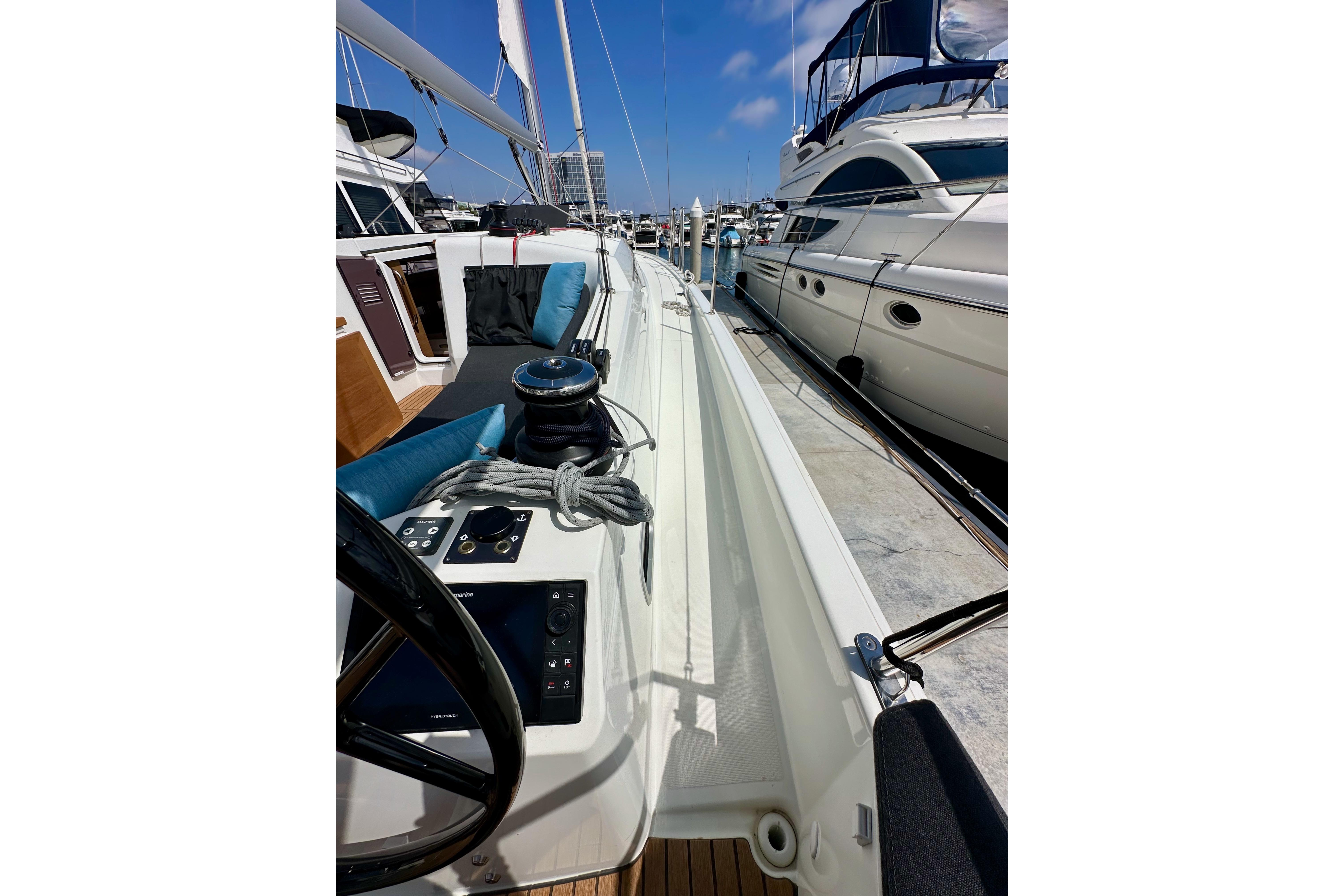 2024 Jeanneau Sun Odyssey 410 sailboat docked, showcasing deck and steering wheel.