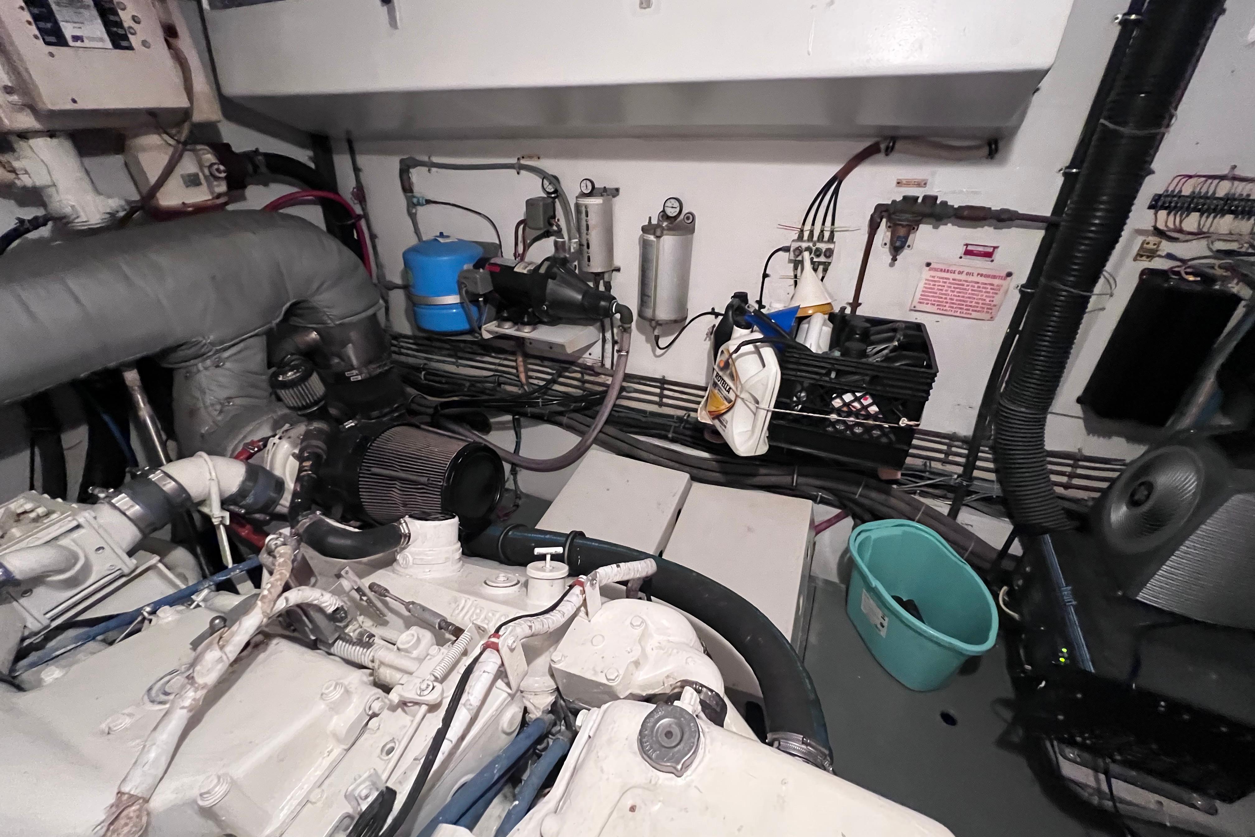 Engine room of 1987 Hatteras 70 Cockpit Motor Yacht with mechanical components and storage.