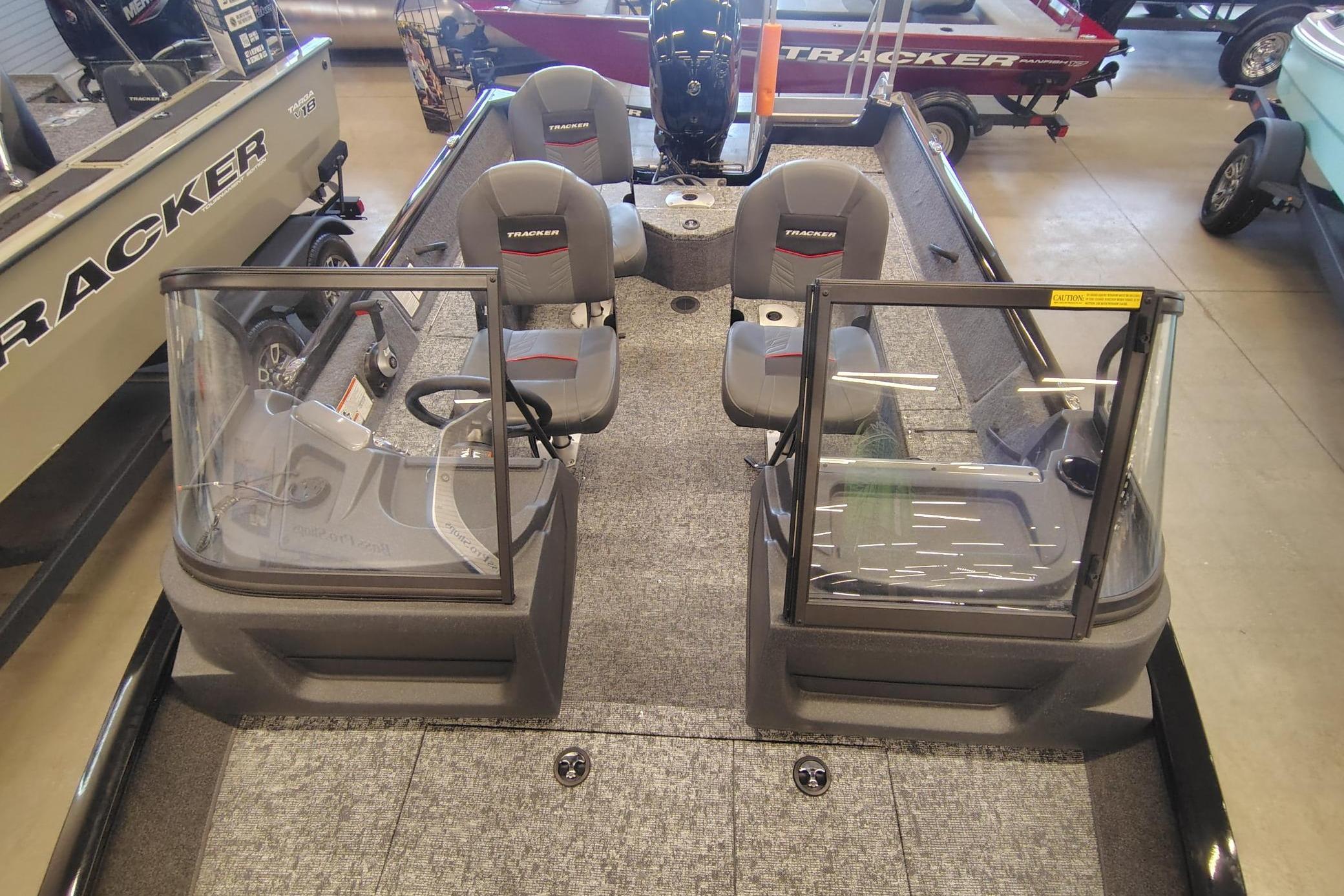 2026 Tracker Pro Guide V-16 WT boat interior with dual seats and windshield in showroom.