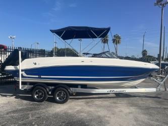 2022 Bayliner VR6 boat on trailer with blue canopy, parked outdoors.