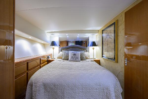 Luxurious bedroom interior of 2000 Viking 50 Convertible yacht with elegant bedding and ambient lighting.