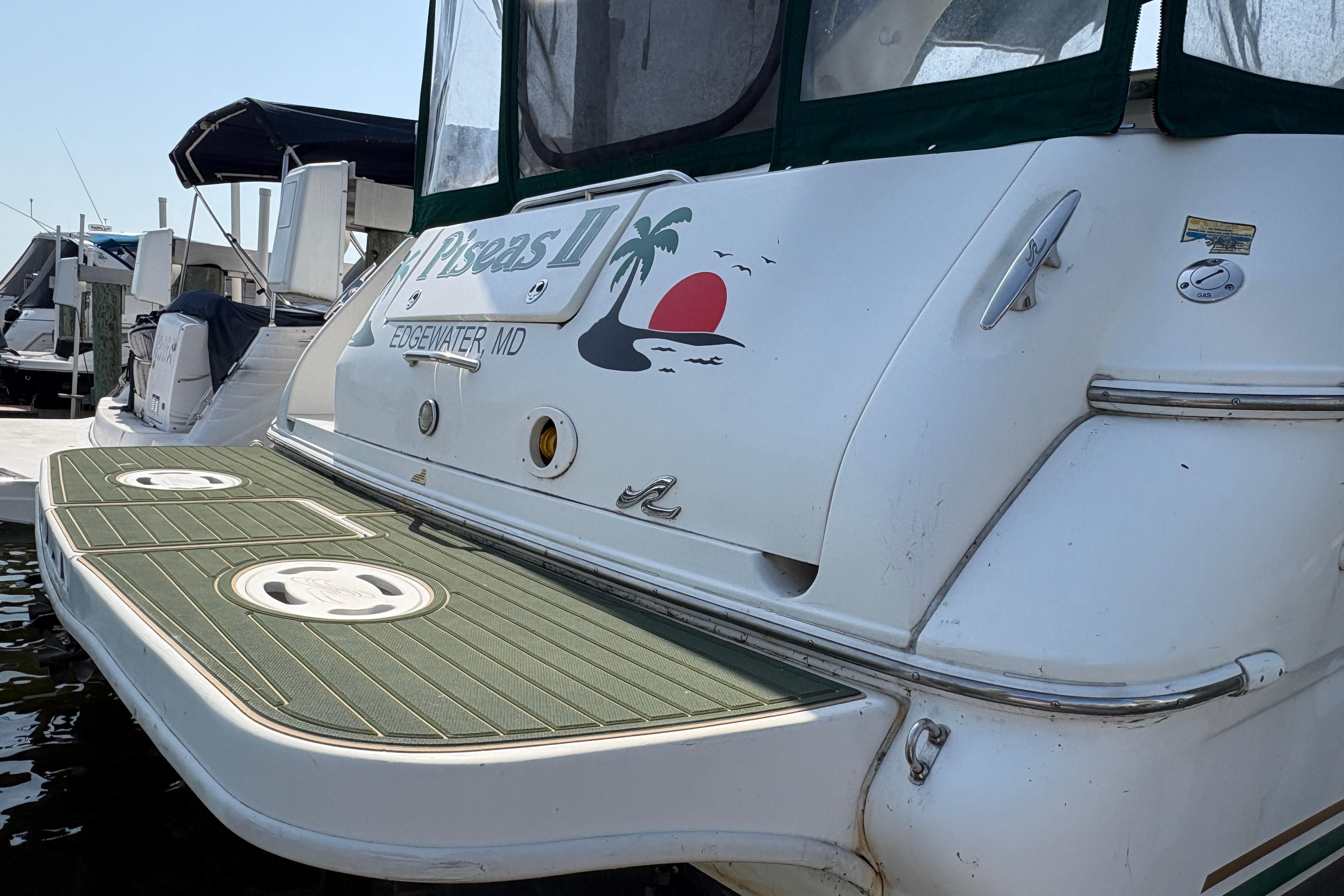 2001 Sea Ray Sundancer 310 boat docked, featuring a custom graphic and swim platform.