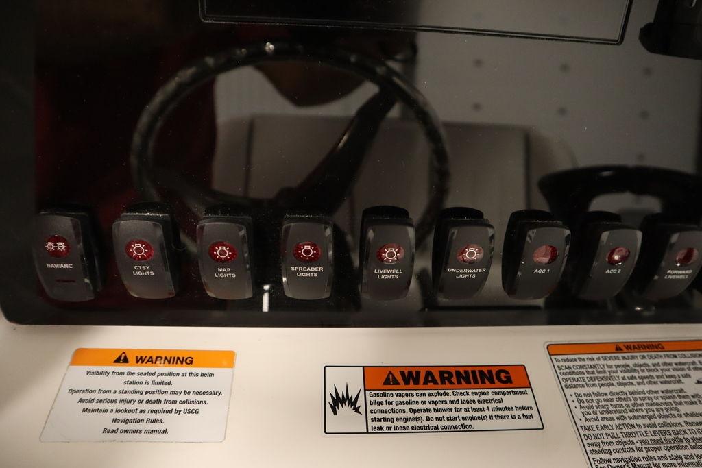 Control panel of 2026 Yamaha Boats 255 FSH Sport E with labeled switches and warning labels.