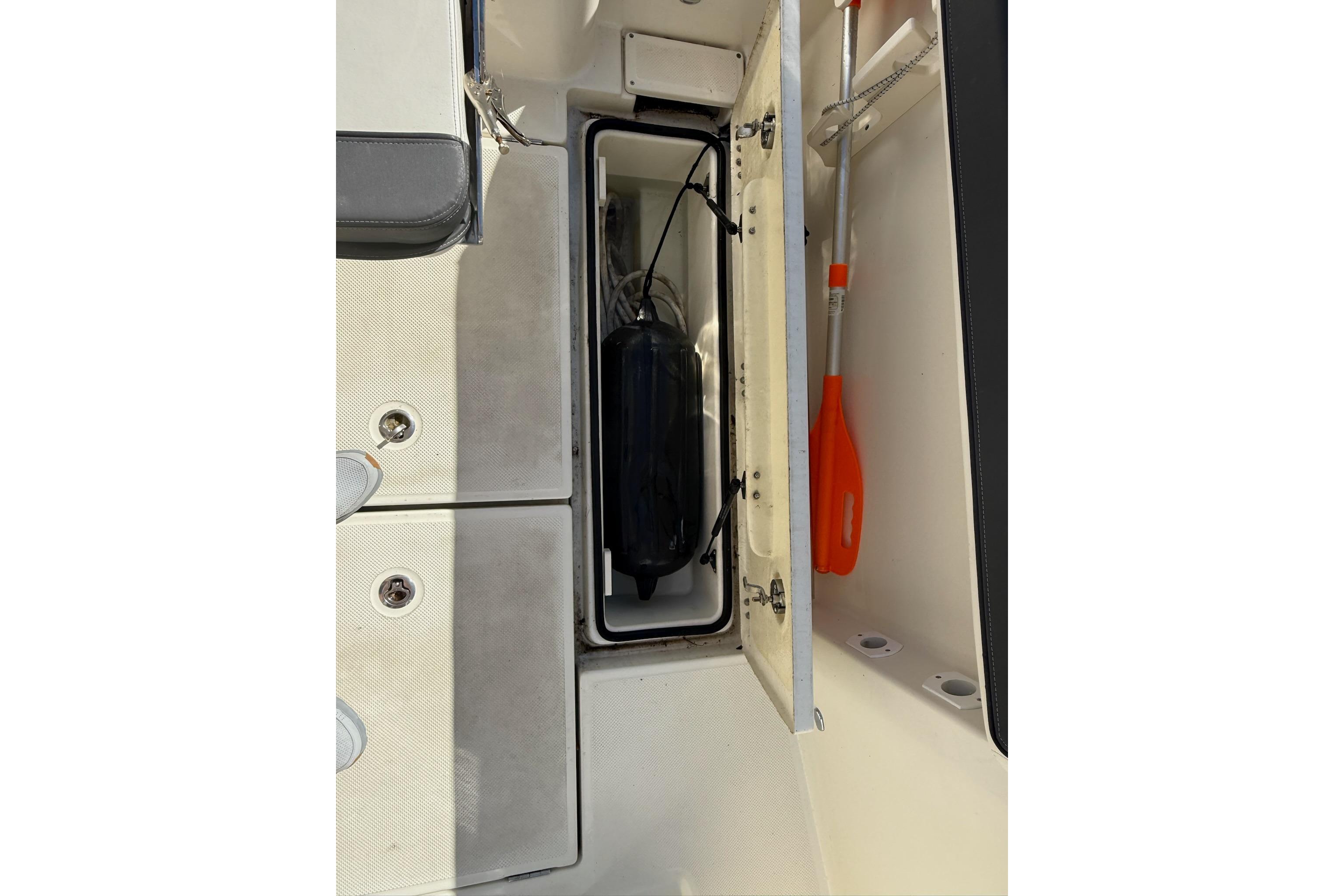 2024 Bayliner Trophy T25 Pilothouse storage compartment with paddle and equipment.