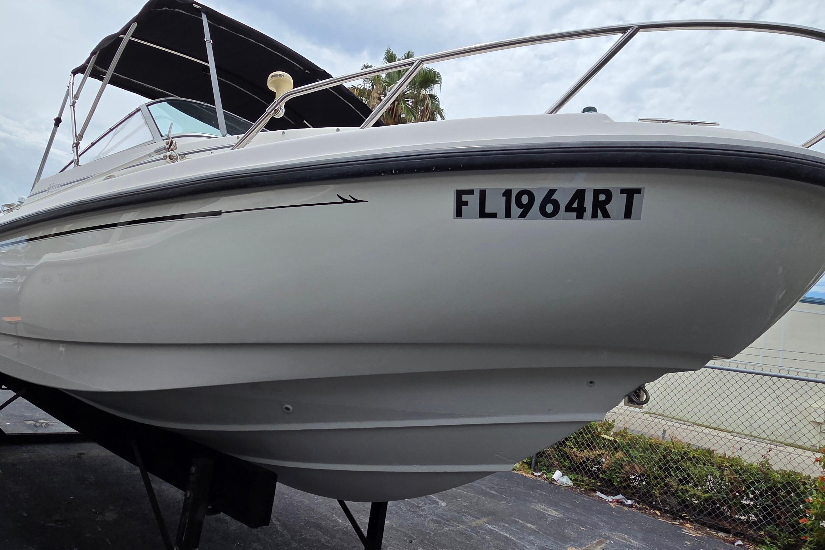 2000 Boston Whaler 21 Ventura boat with registration FL1964RT, docked outdoors.