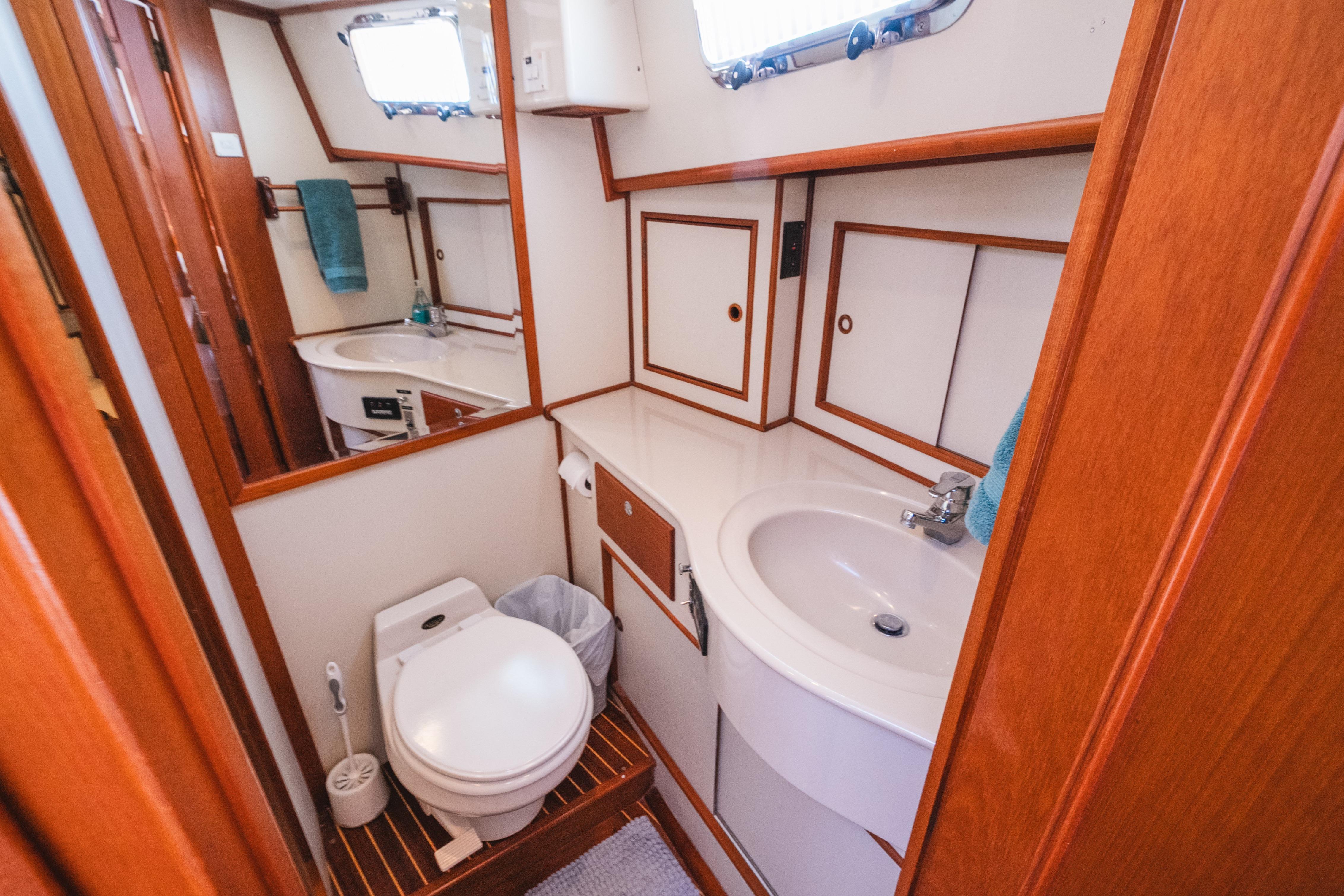 1999 Grand Banks 49 Eastbay HX yacht bathroom with wooden accents and modern fixtures.