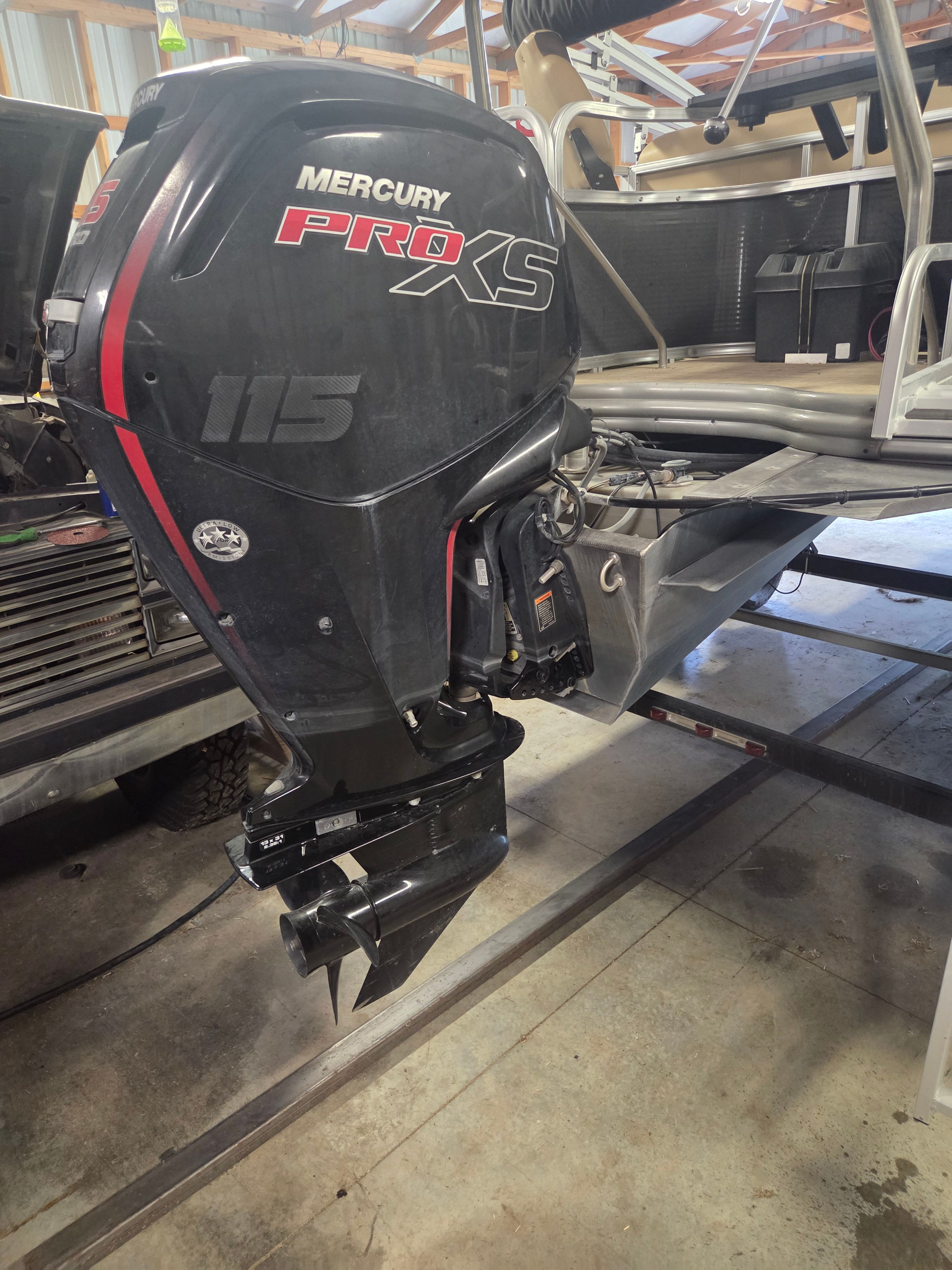 A Mercury Pro XS outboard motor on a boat indoors.