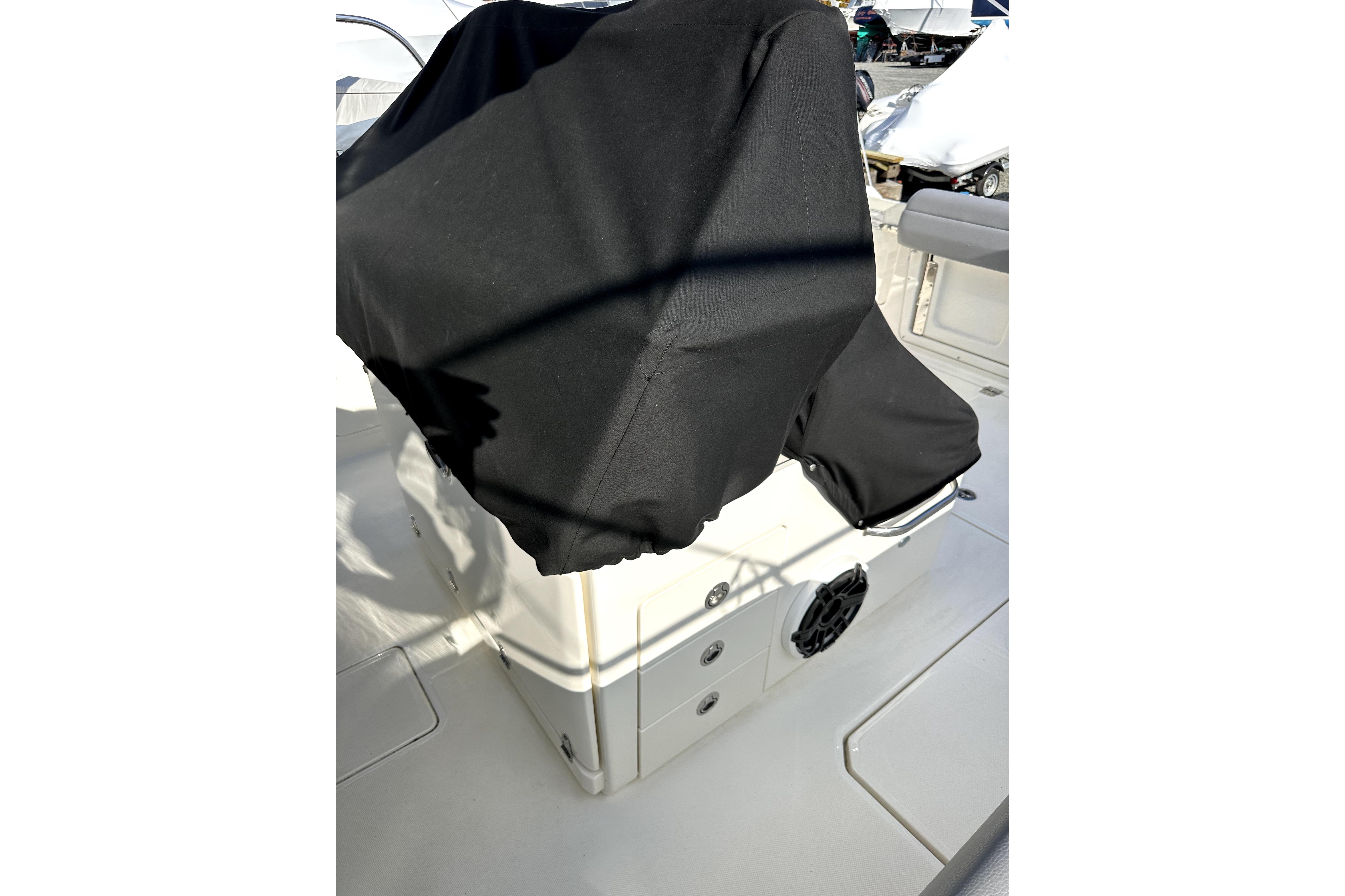 2023 Boston Whaler OUTRAGE boat interior with covered console and seating area.