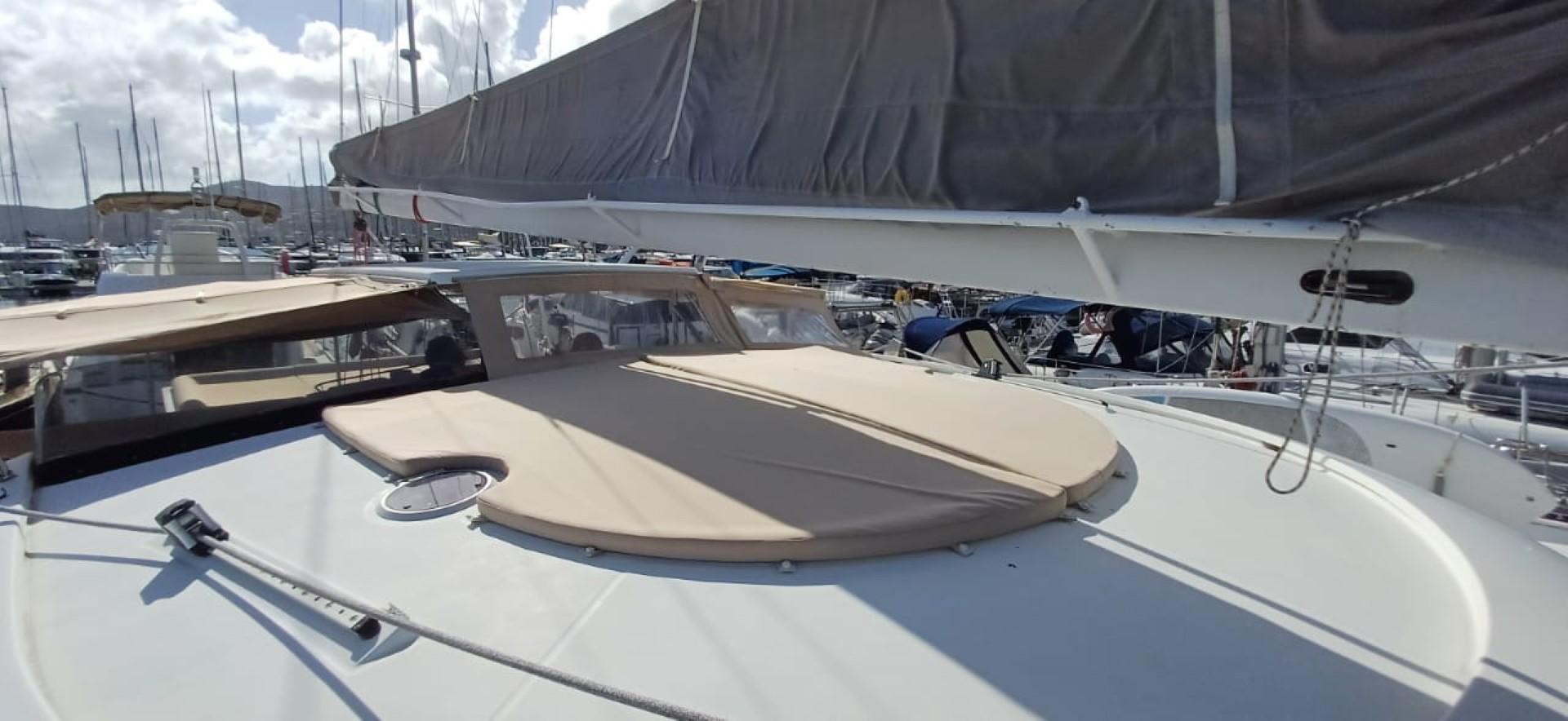 2008 Fountaine Pajot Eleuthera 60 catamaran deck with sail and sunroof in marina.