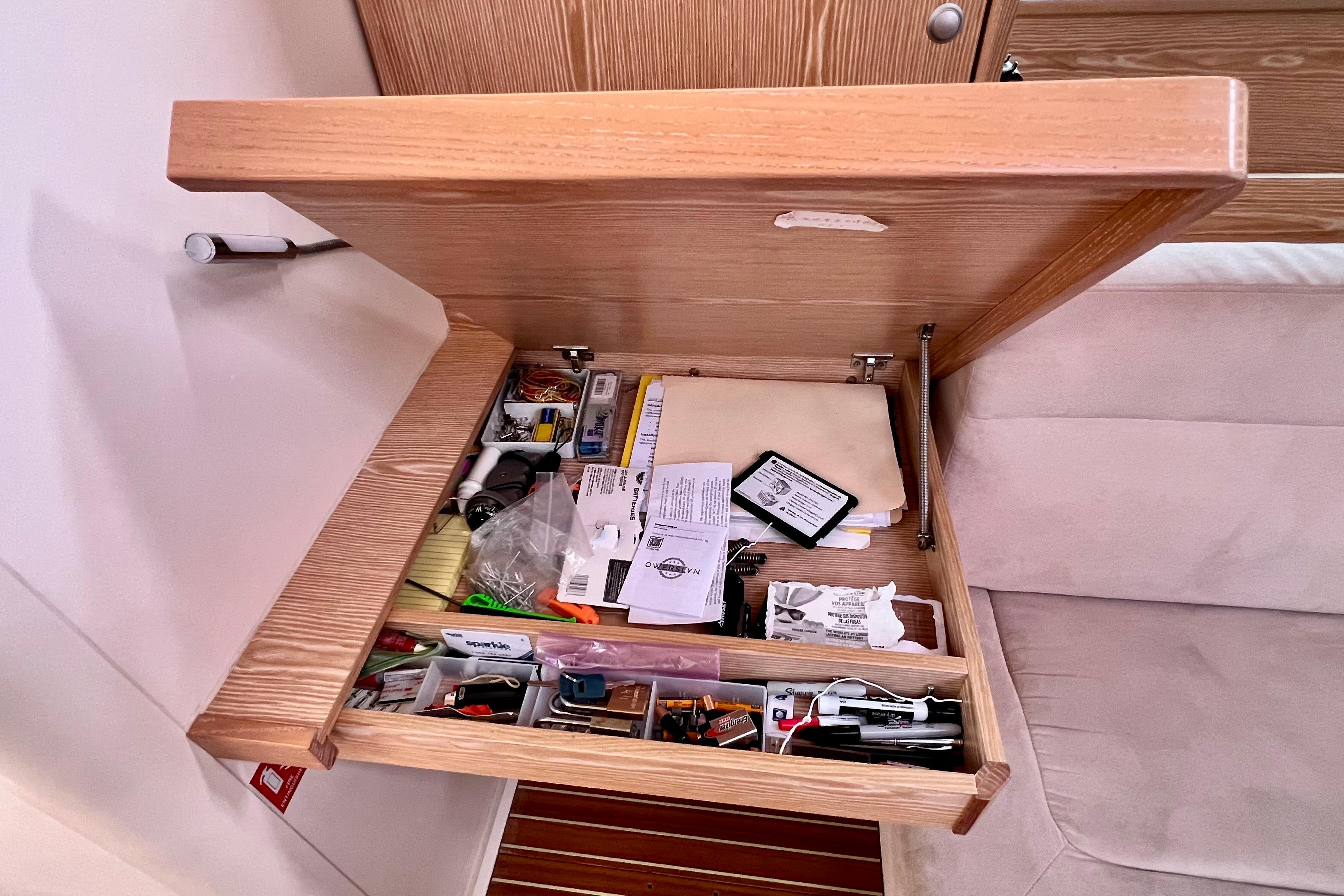 Open drawer on 2016 Hanse 455 yacht, containing various tools and documents.