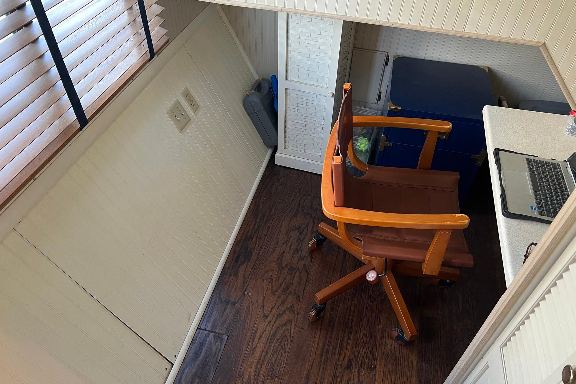 Cozy workspace on a 1993 Sumerset houseboat with wooden chair and laptop.