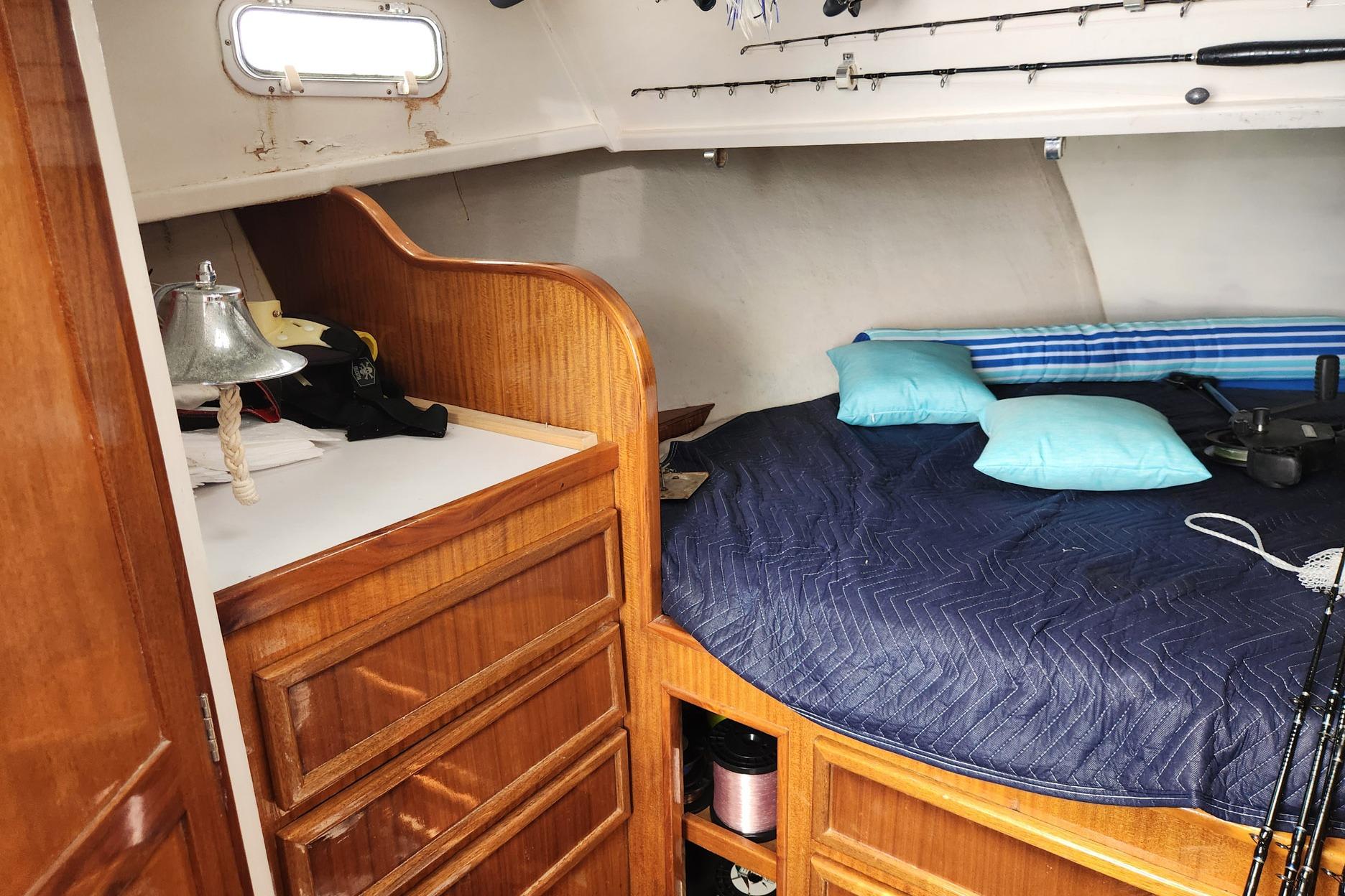 Cozy cabin interior of 1987 Young Brothers Custom Sport Fish boat with wooden cabinetry.