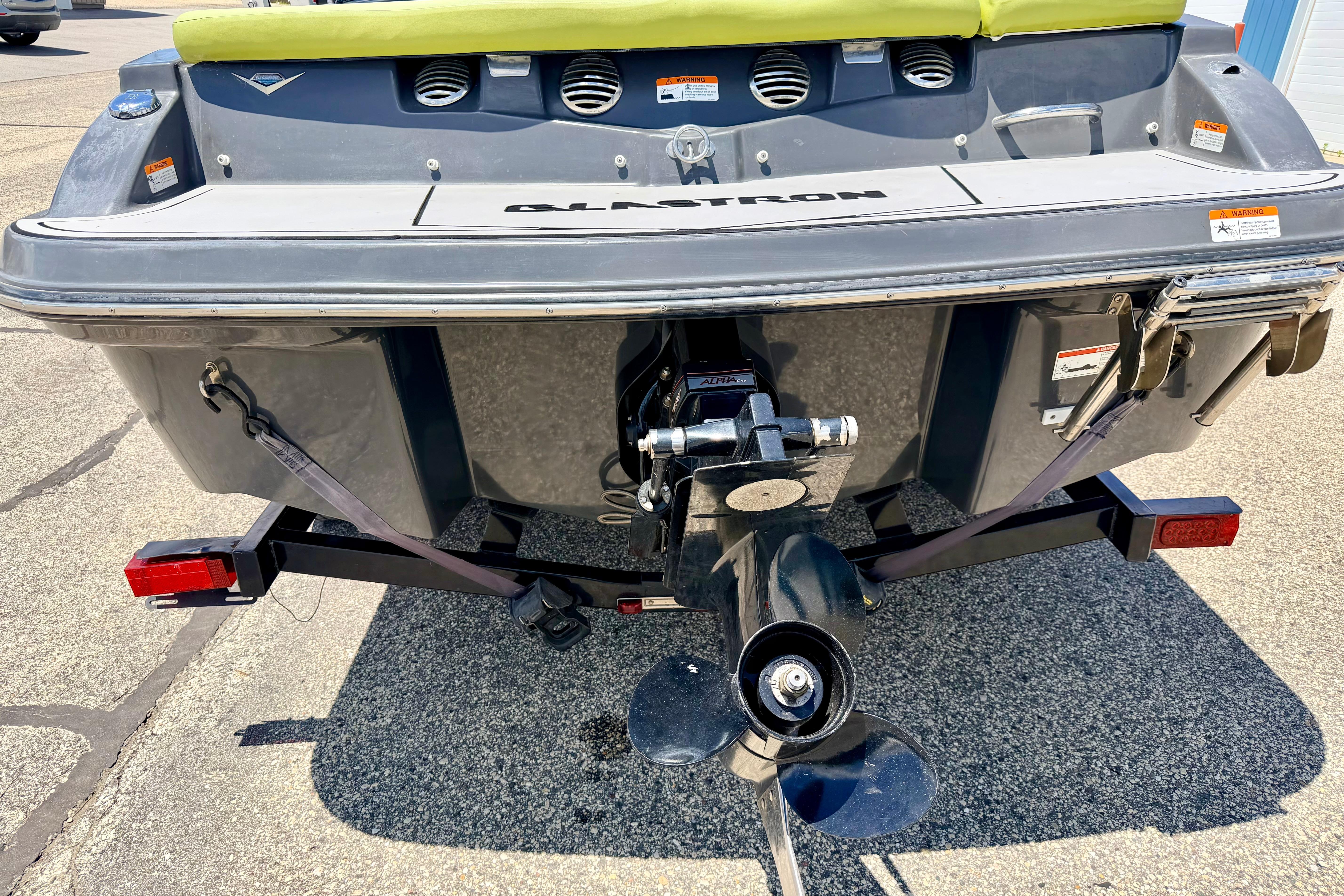 Rear view of 2018 Glastron GT 185 boat on trailer, showing propeller and hull details.