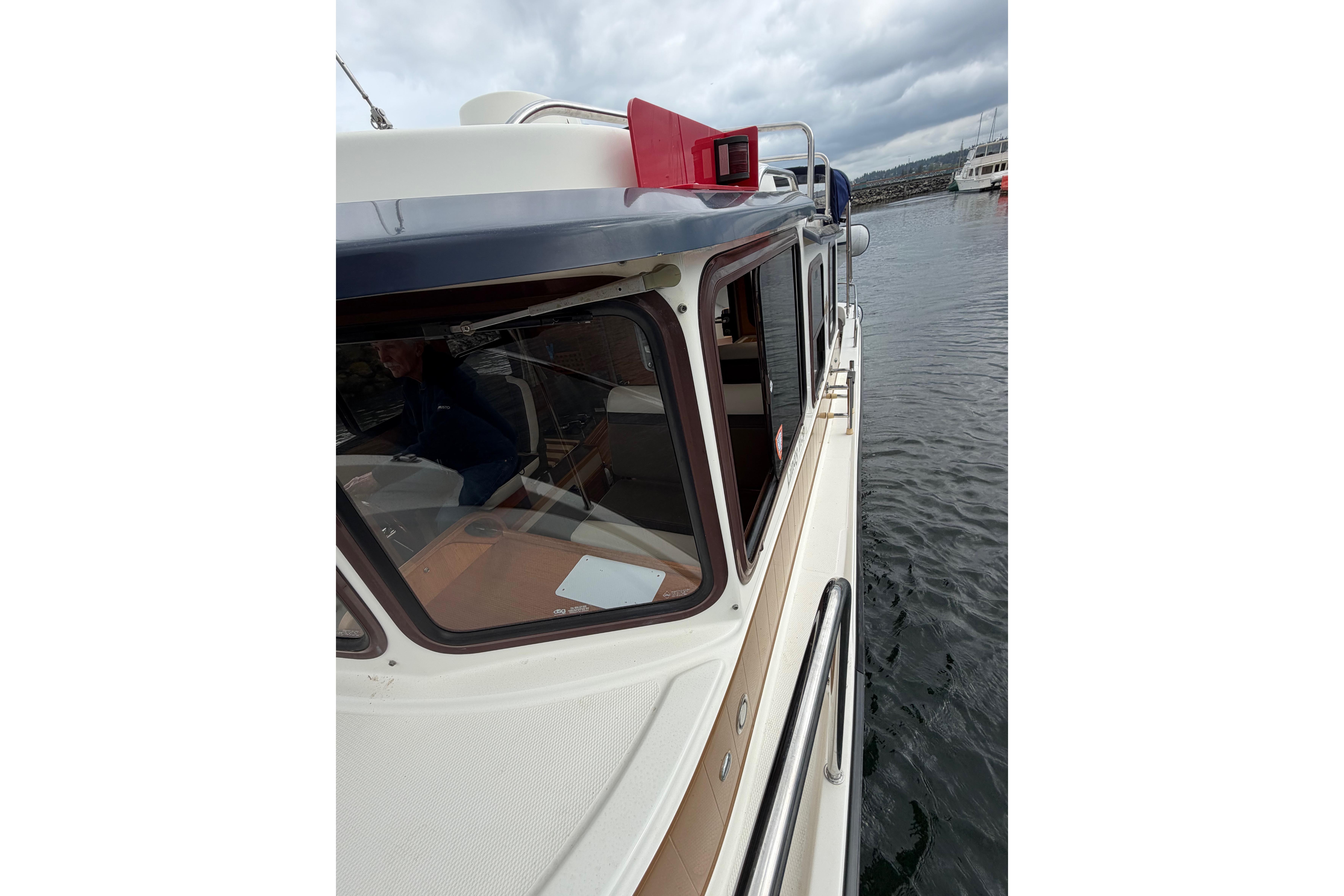 2014 Ranger Tugs R-25 SC boat docked on a cloudy day.