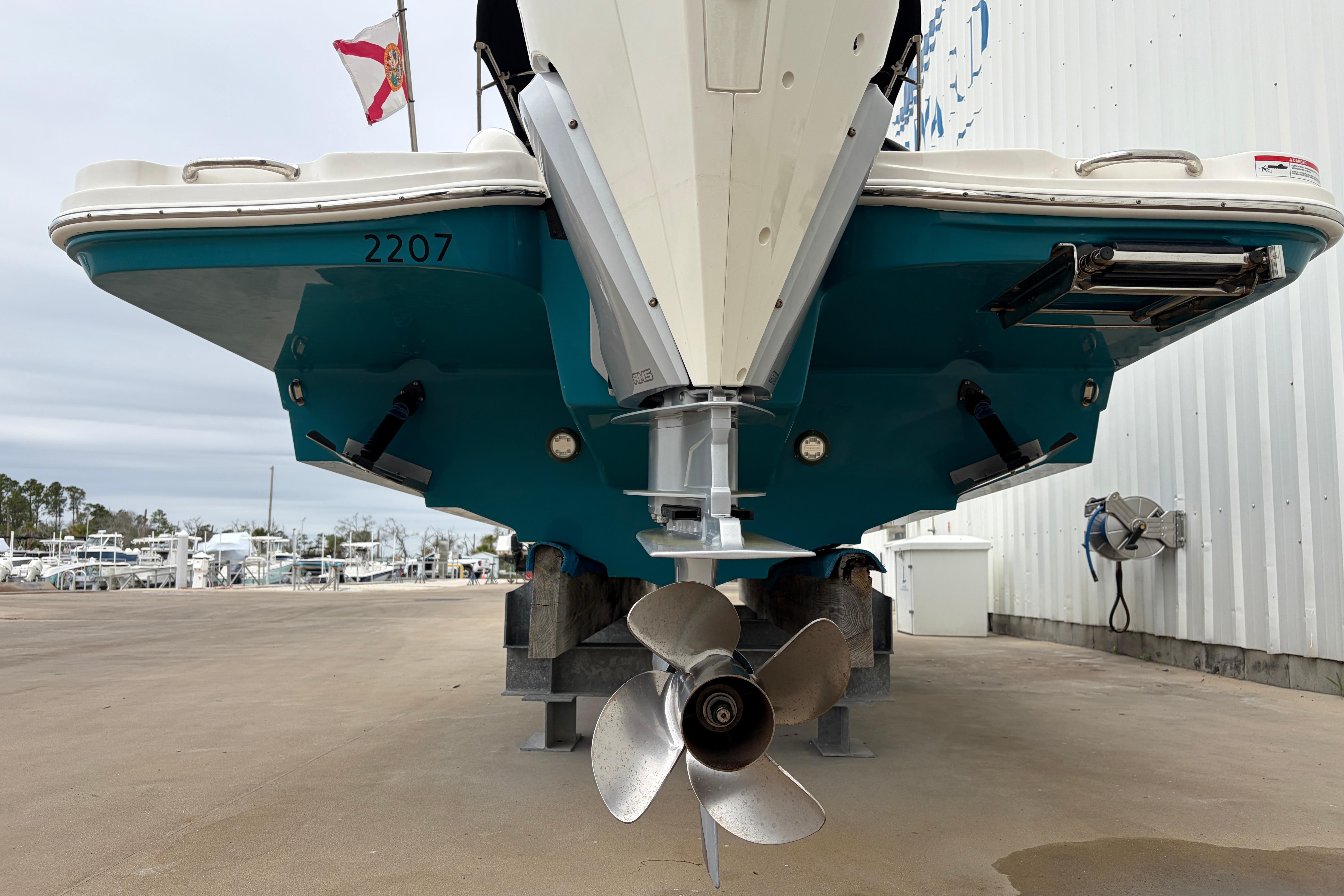 2024 Sea Ray SDX 270 Outboard boat, rear view with propeller, docked outdoors.
