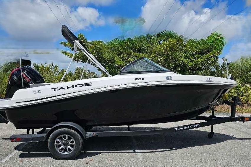 2025 Tahoe 185 S boat on trailer, parked outdoors under a blue sky.
