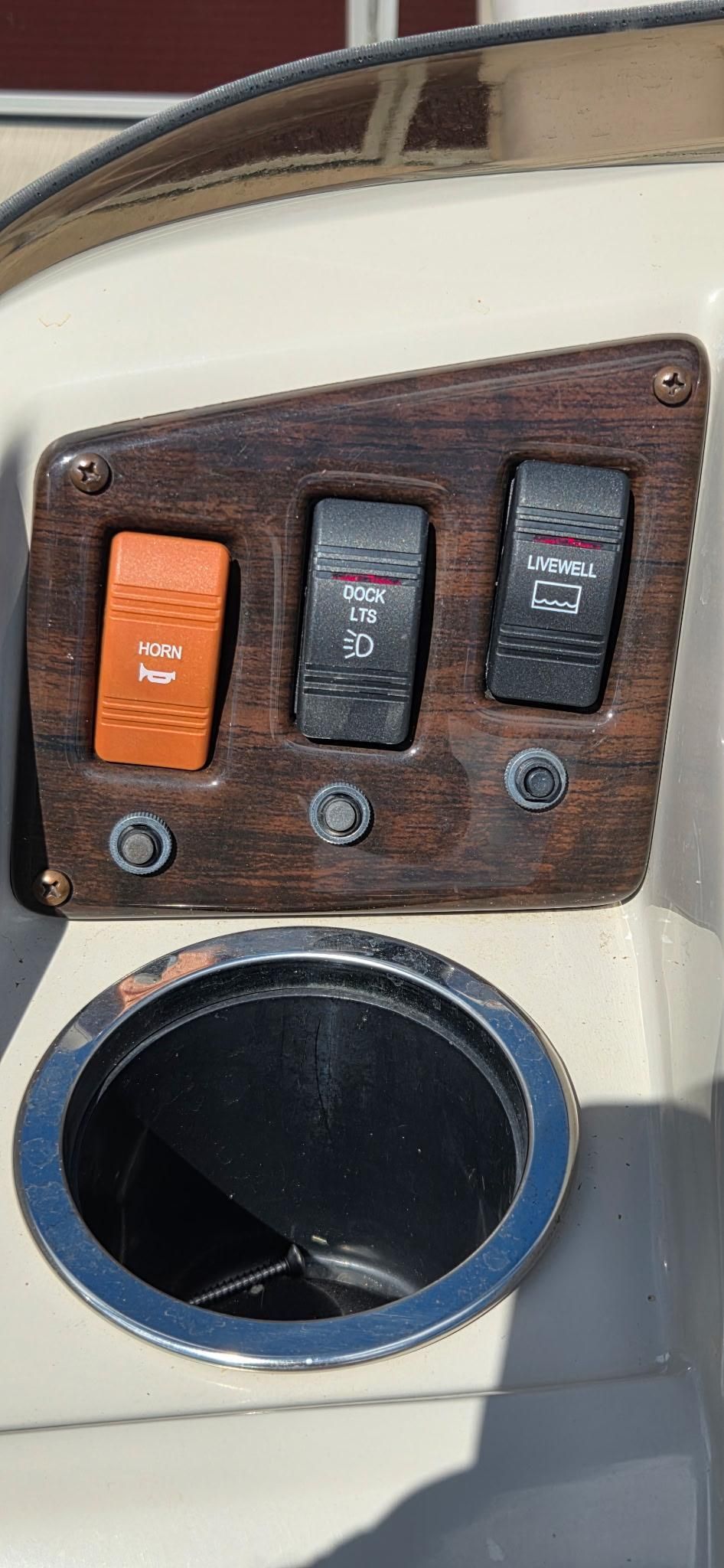 Close-up of a boat control panel with switches for horn, dock lights, and livewell.