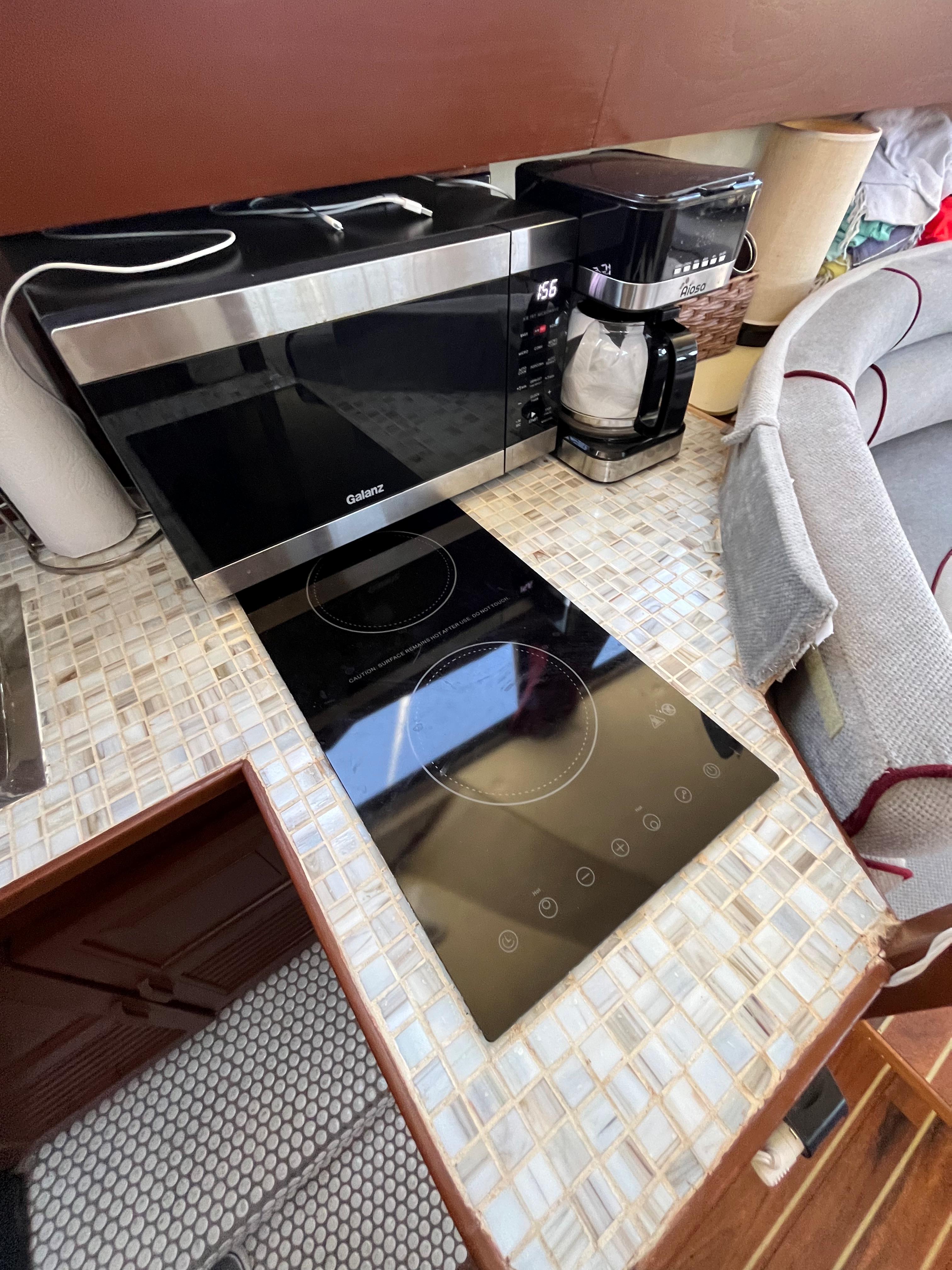 1987 Scand Baltic kitchen with modern appliances, microwave, coffee maker, and induction cooktop.