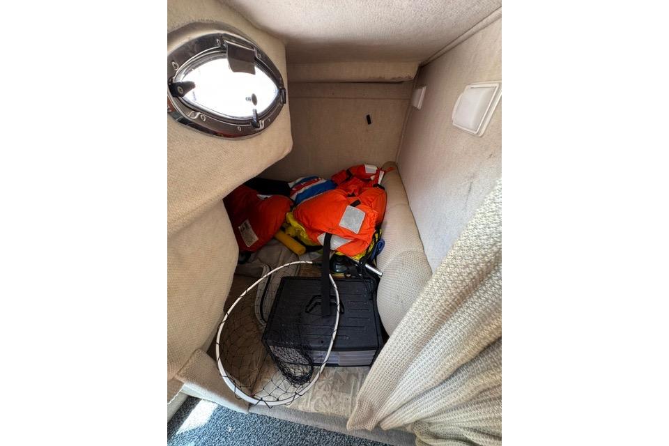 Interior cabin of 2004 Sea Ray 240 Sundancer with life jackets and fishing net.