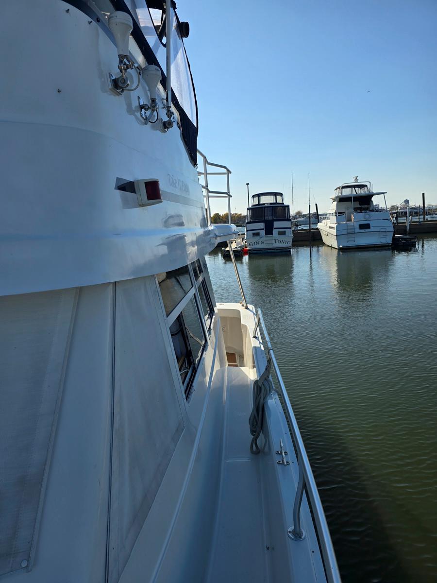 1997 Mainship 350 Trawler docked, side view with other boats in marina.
